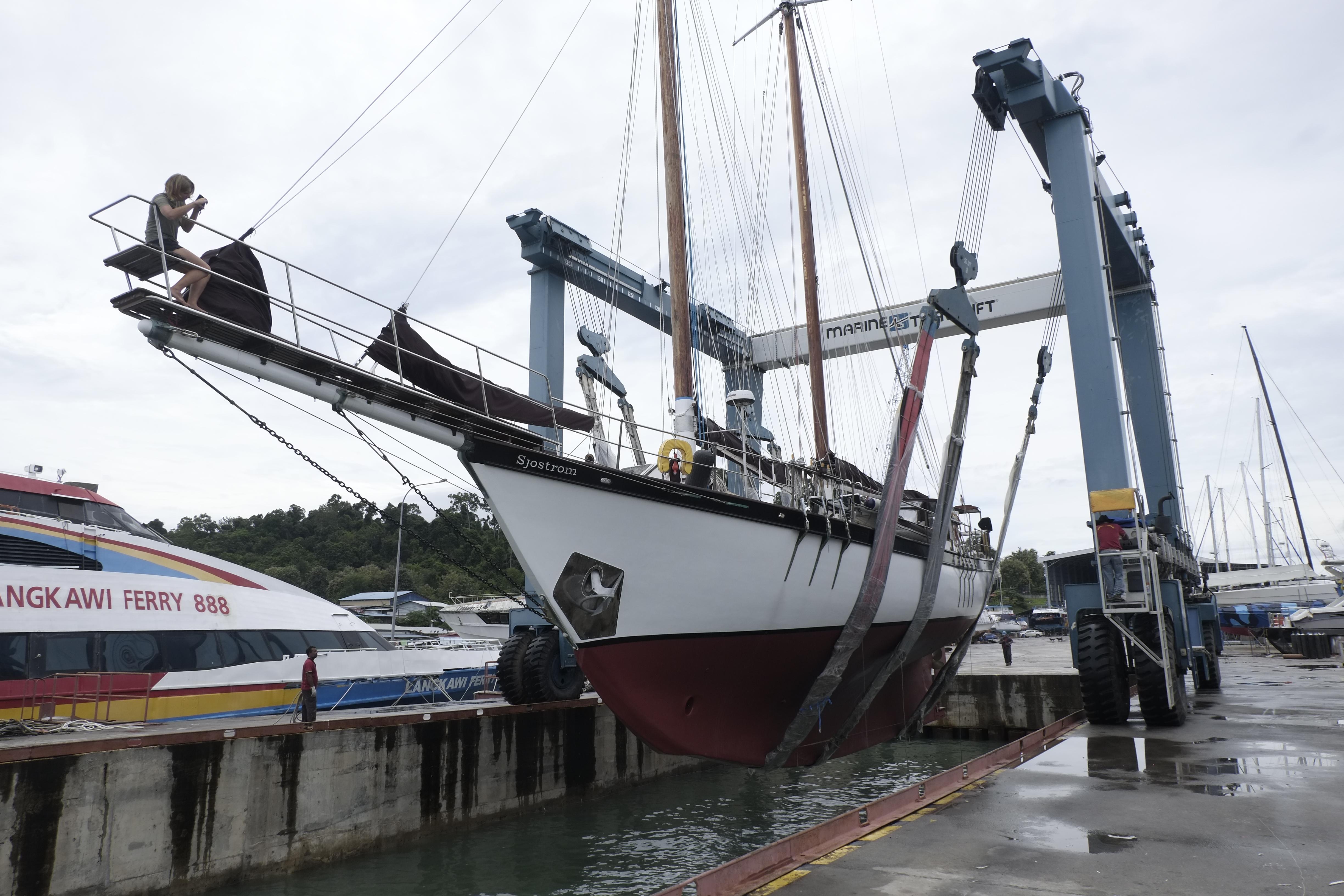 Custom Bud Macintosh schooner, 2006, being lifted at a marina with a travel lift.