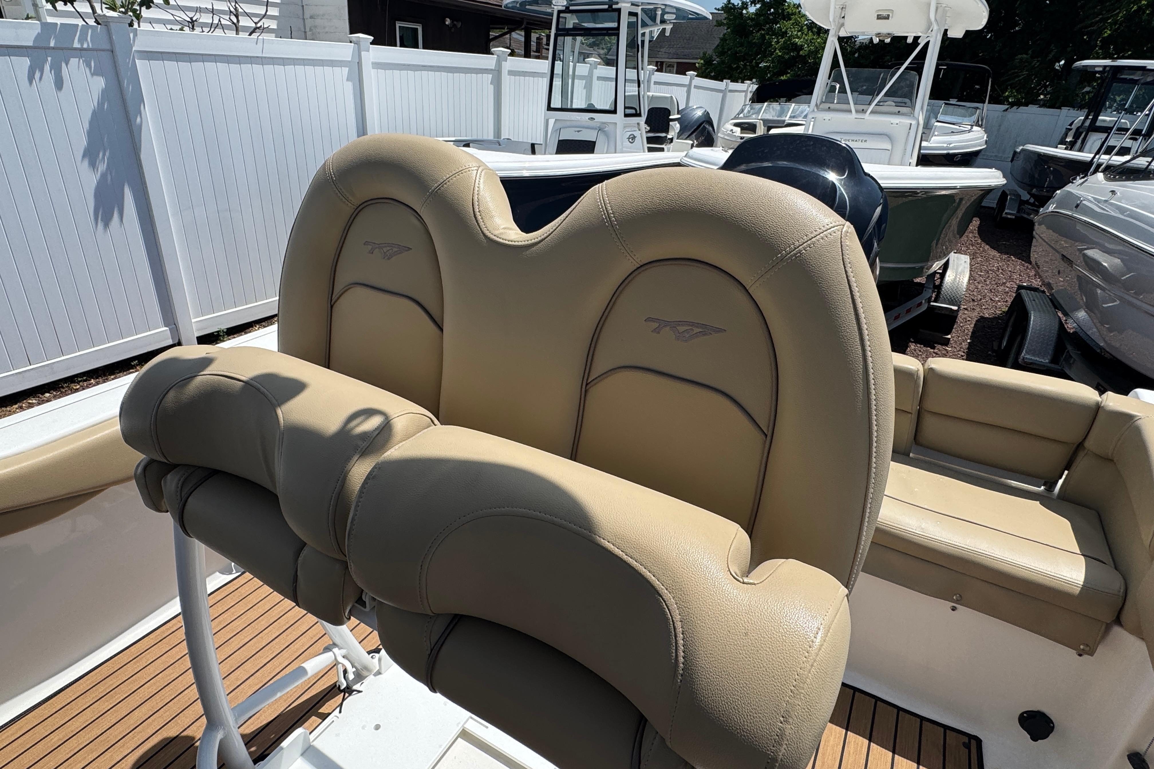 2016 Tidewater 230 LXF boat with tan seating and white fencing in the background.