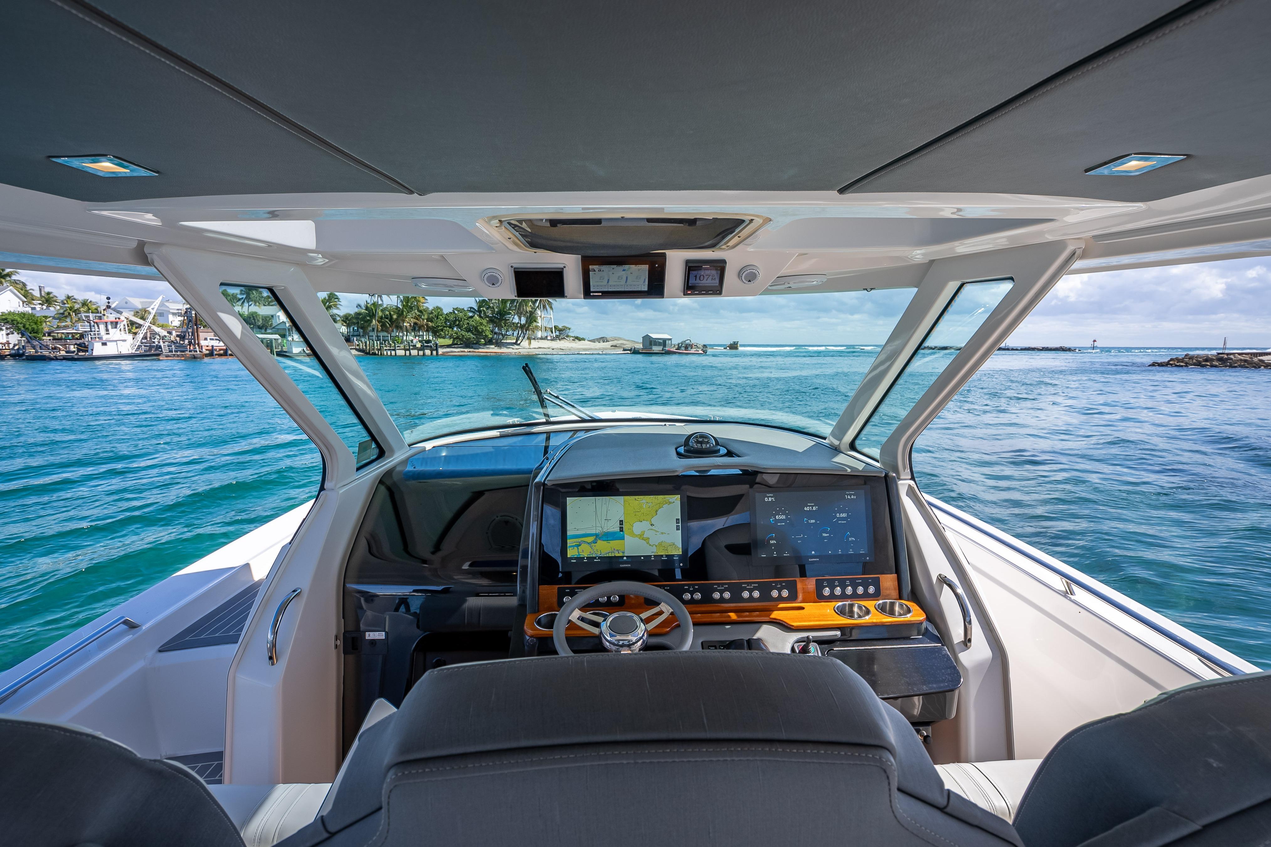 2019 Tiara Sport 38 LS boat cockpit with navigation screens, steering wheel, and ocean view.