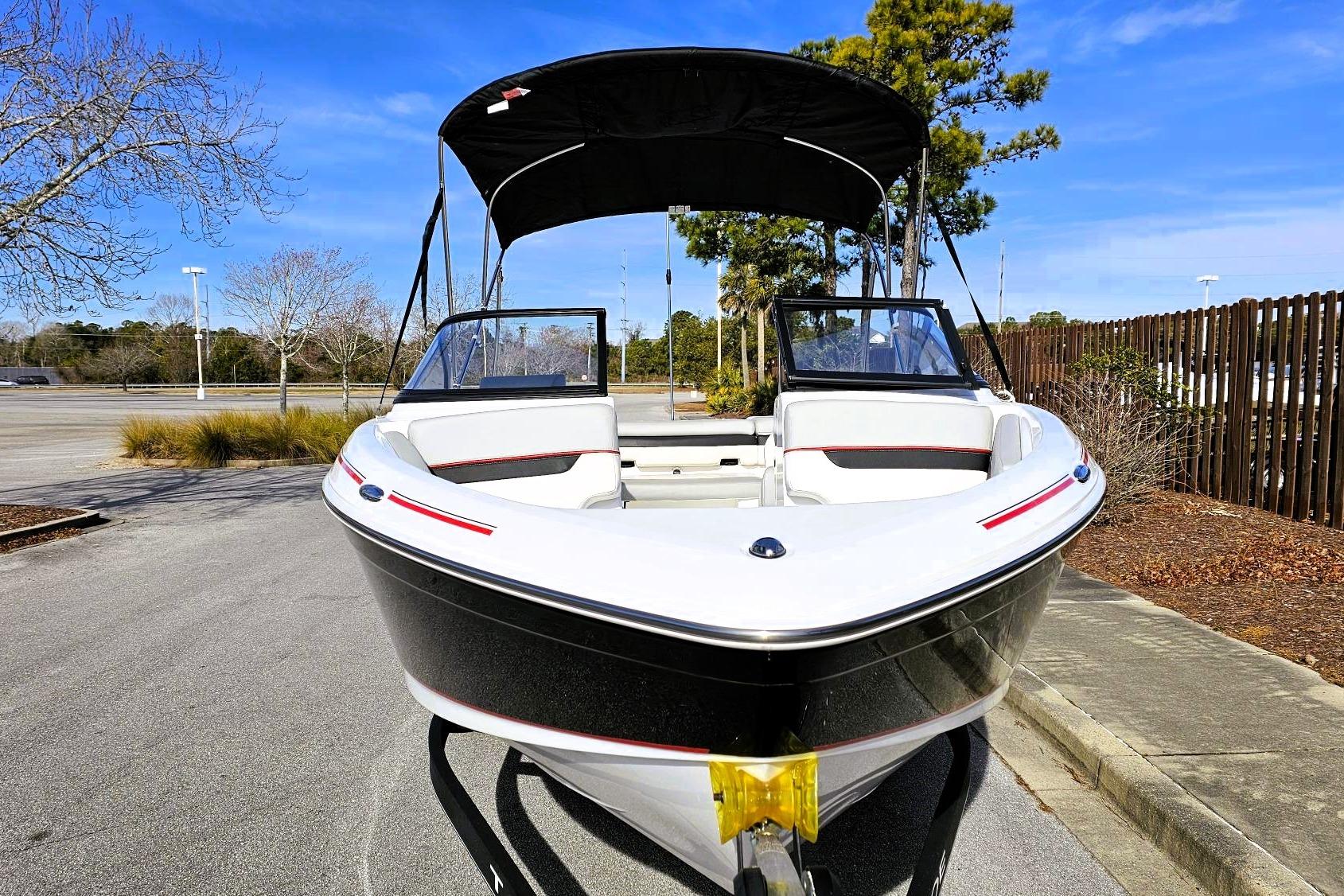 2023 Tahoe 210 Si boat with canopy, parked outdoors on a sunny day.