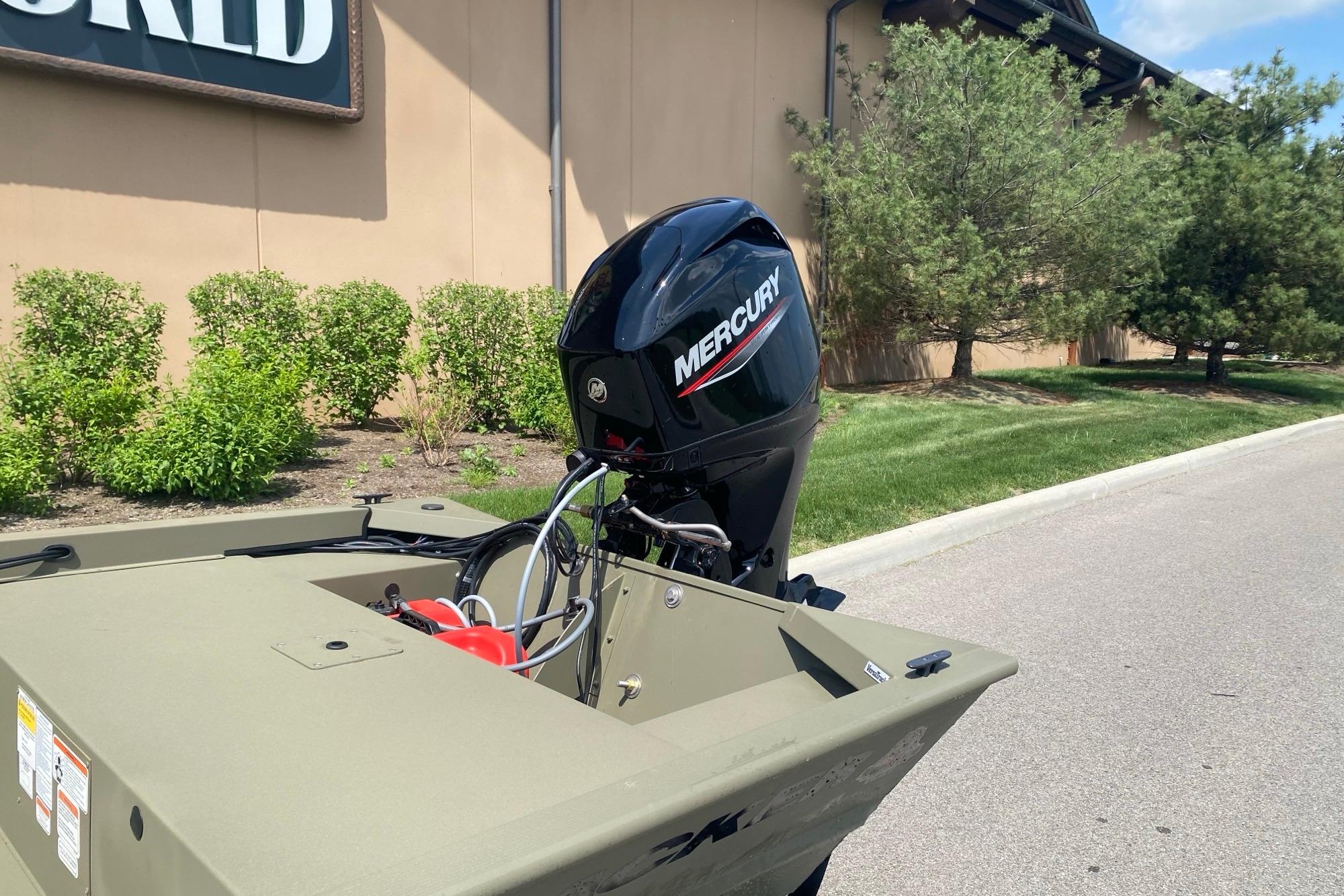 2026 Tracker Grizzly 1648 SC boat with Mercury outboard motor, parked outdoors.