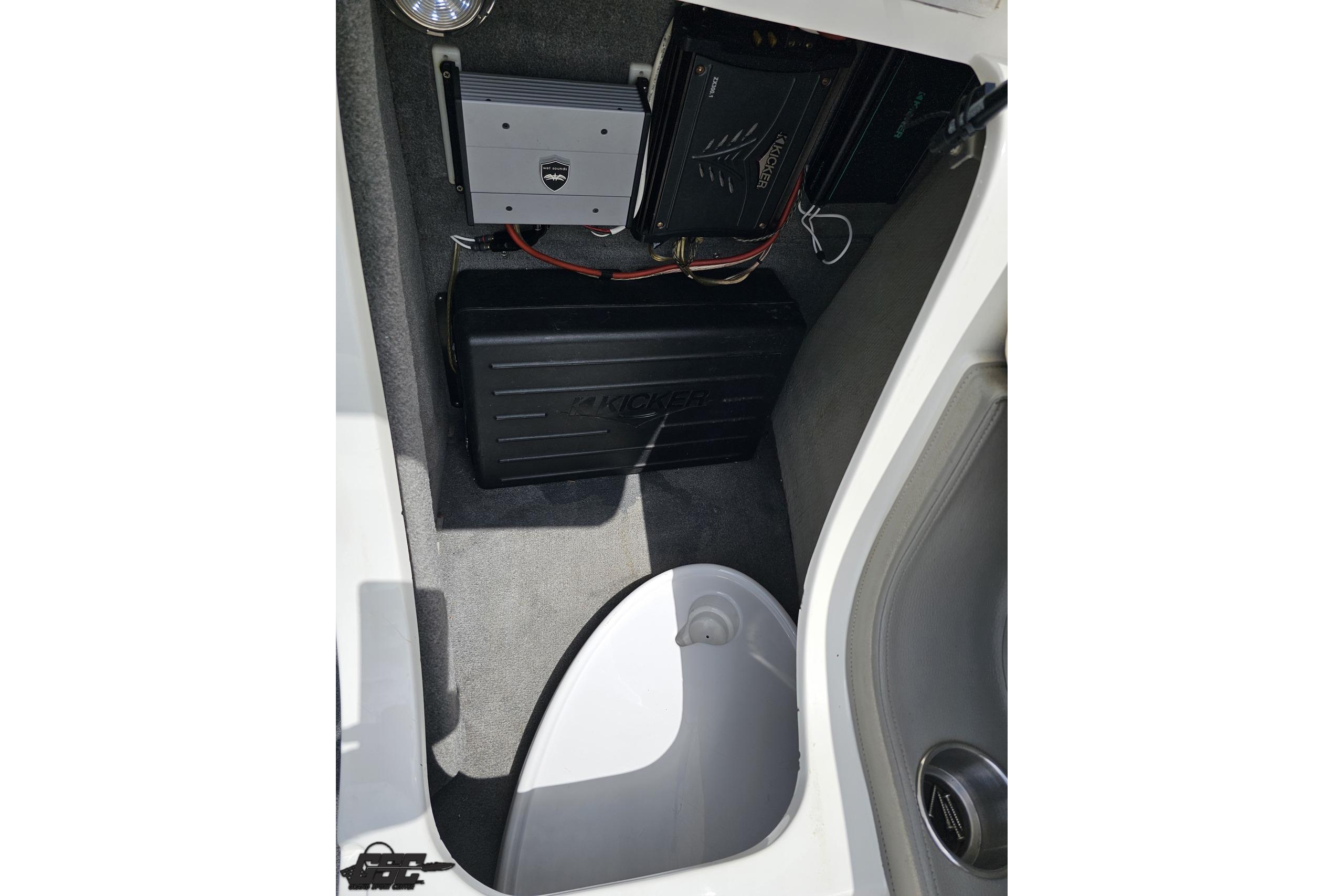 2010 Cobalt 232 WSS boat interior showing audio equipment and storage compartment.