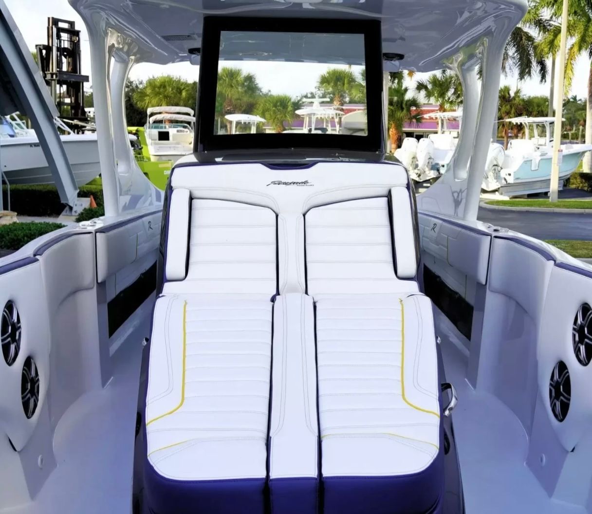 The image shows a modern boat cockpit with white upholstery and a large screen.