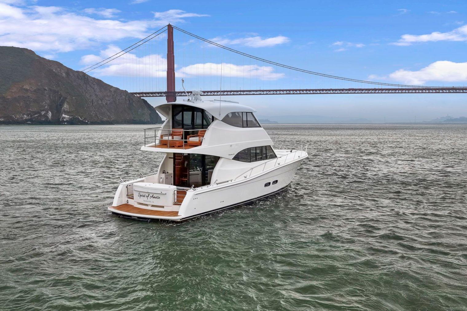 2014 Maritimo M50 yacht cruising near a large suspension bridge.