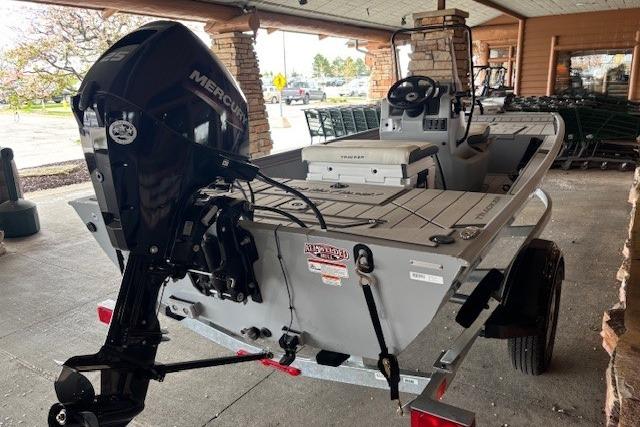 2026 Tracker Bass Tracker Classic CC boat with Mercury engine, parked under a covered area.