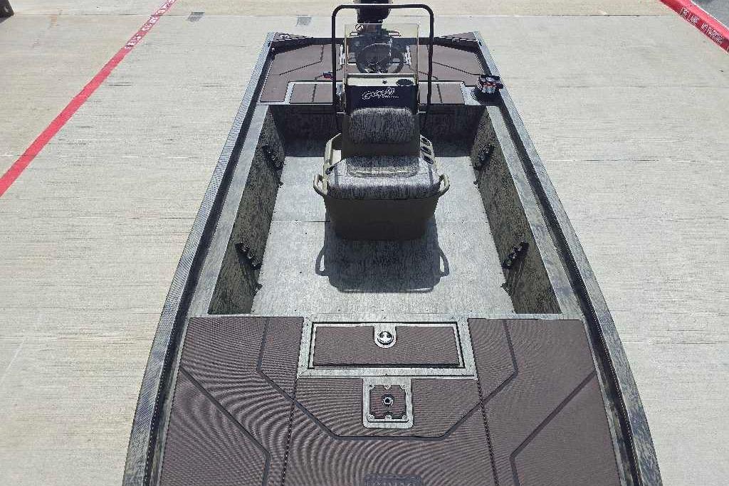 2026 Tracker Grizzly 1860 CC boat with center console and seating, parked on concrete.
