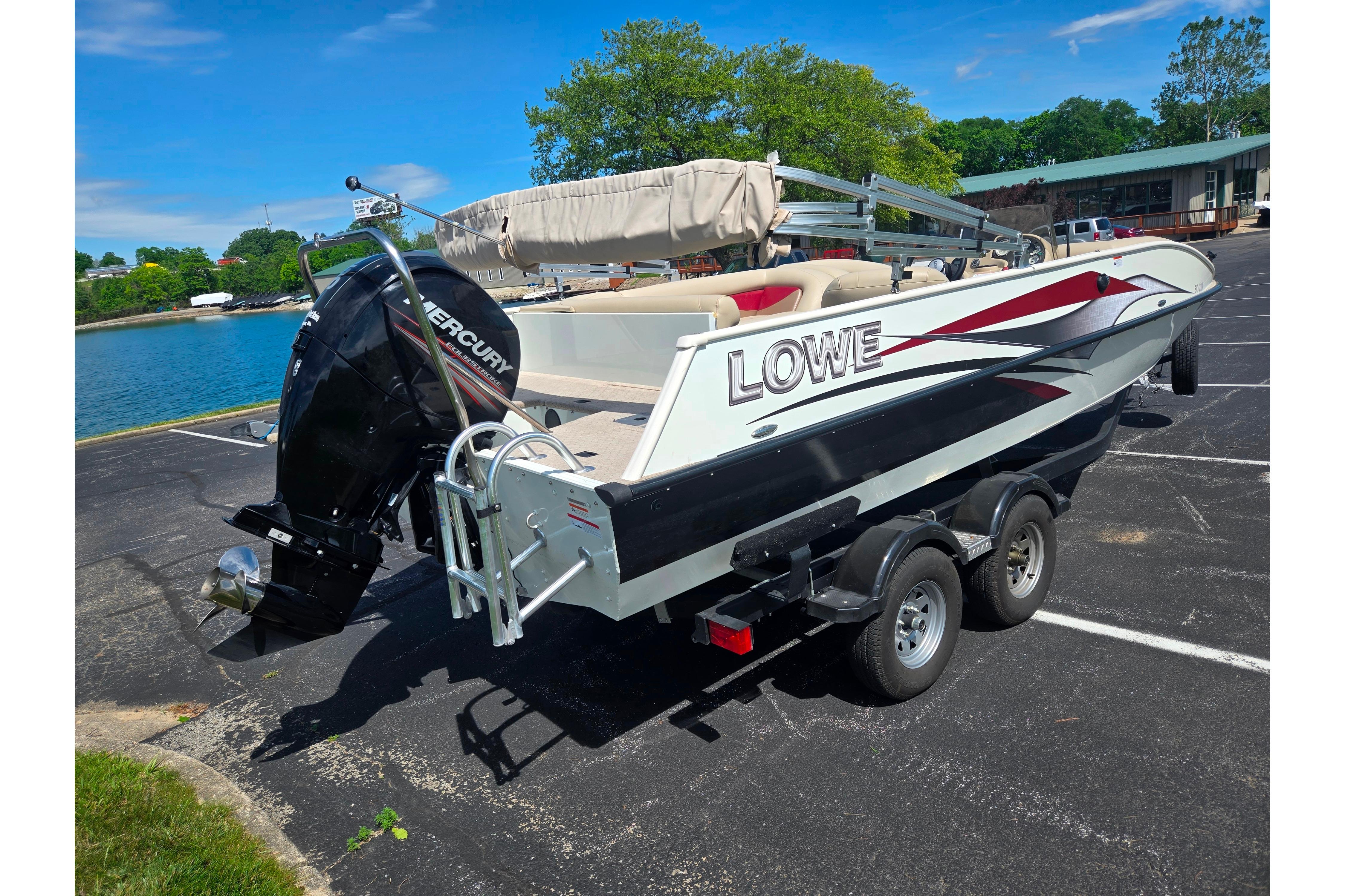 2015 Lowe Sport Deck 224 boat on trailer by a lake.