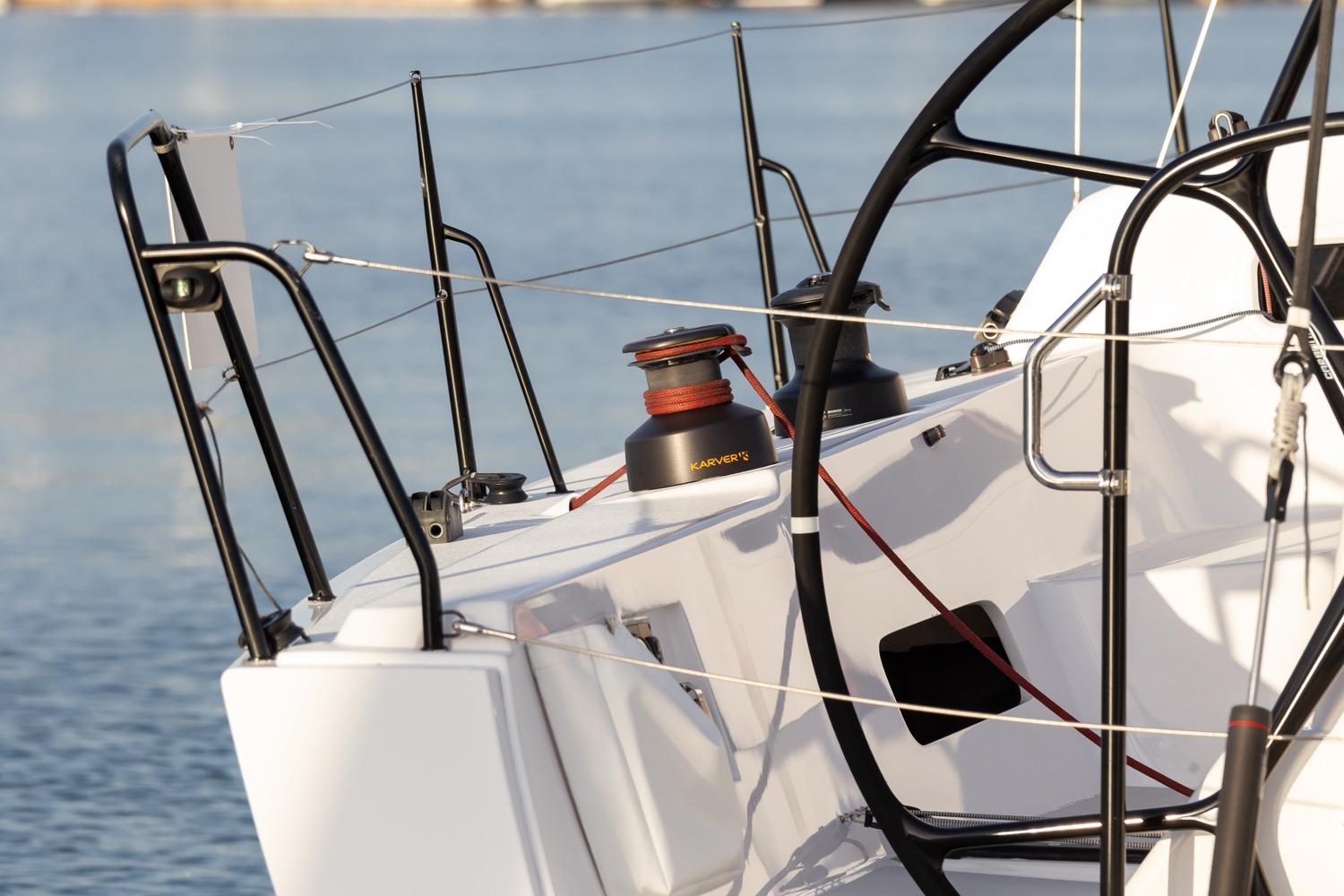 2008 J Boats J/122 sailboat deck with winch and steering wheel, docked on calm water.