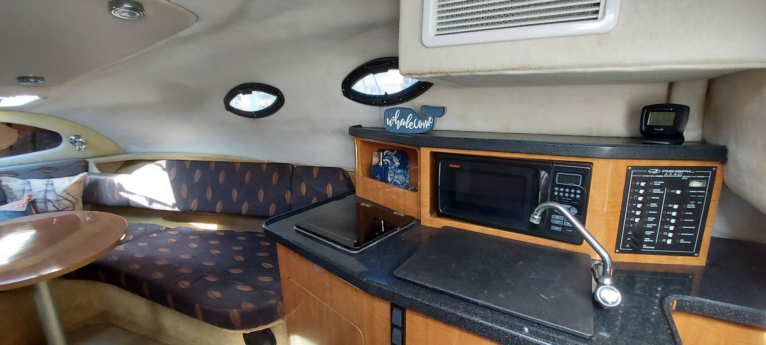 Interior of a 2004 Regal Commodore 2465 yacht with kitchen and seating area.