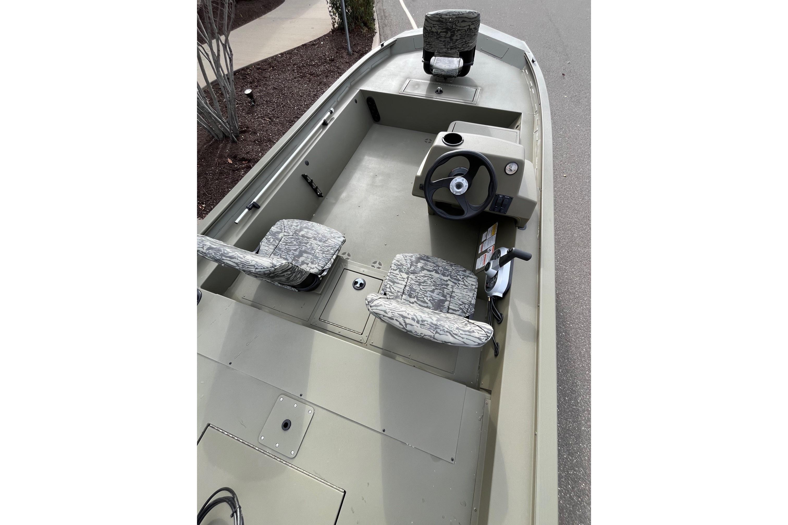 2026 Tracker Grizzly 1754 SC boat interior with camo seats and steering console.