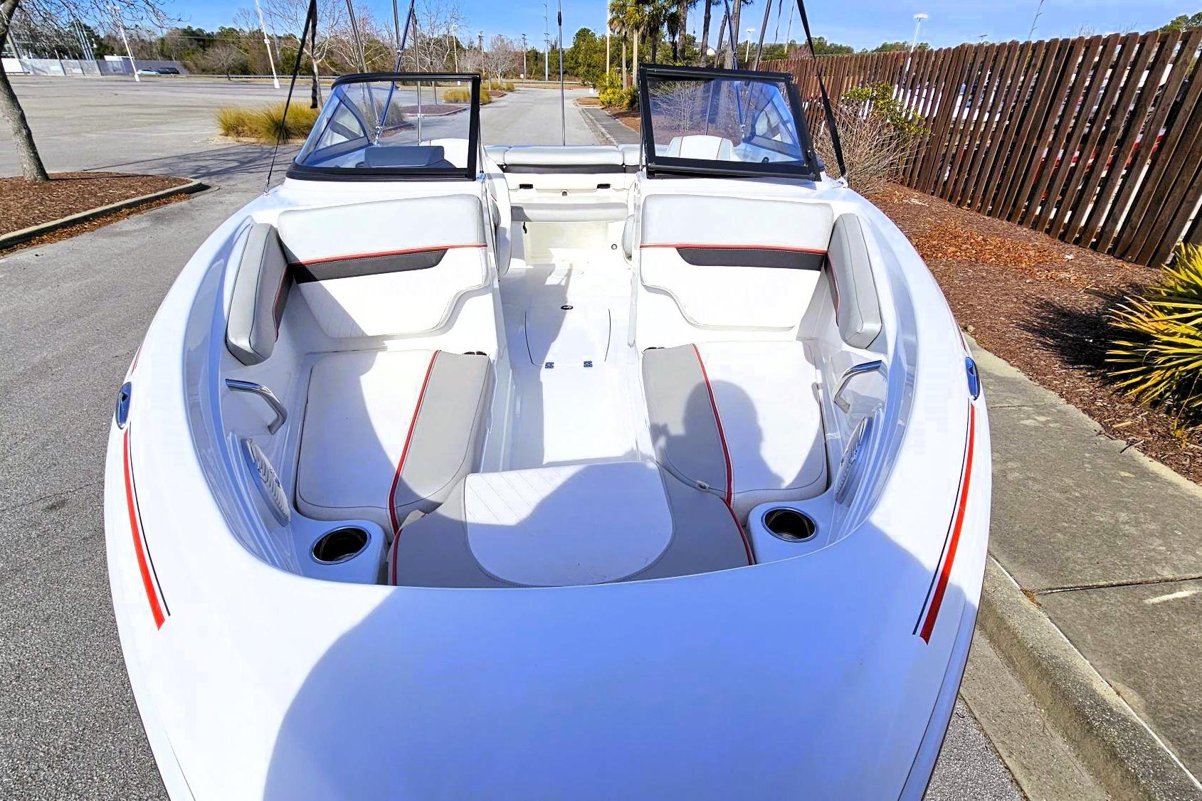 2023 Tahoe 210 Si boat interior with white and red seating, parked outdoors.