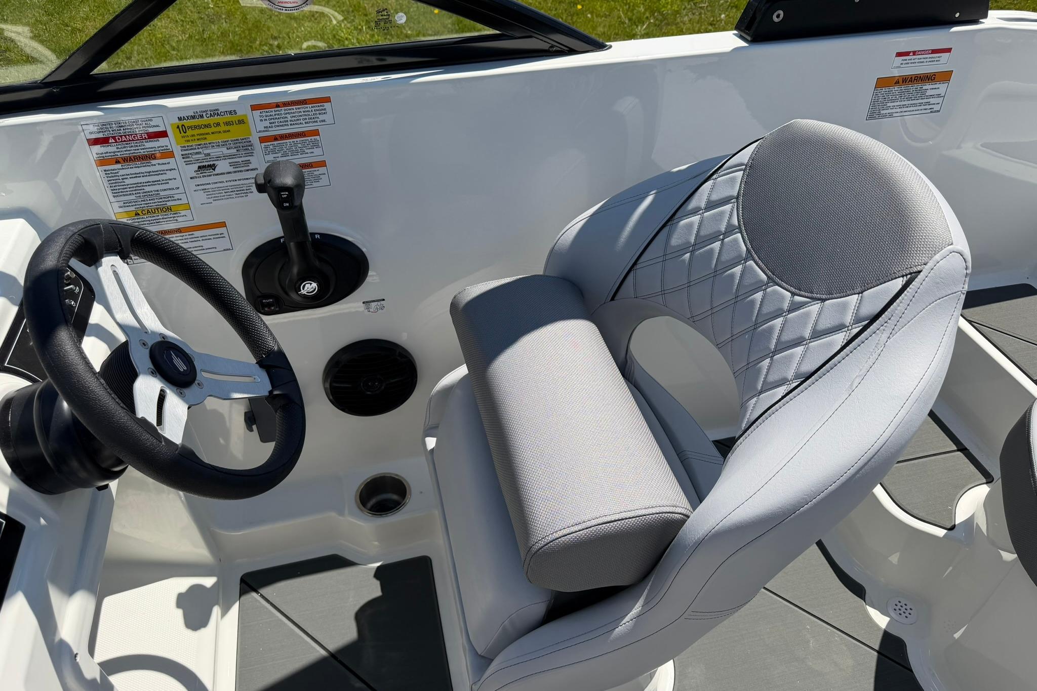 2026 Bayliner D20 boat cockpit with steering wheel and cushioned seat.
