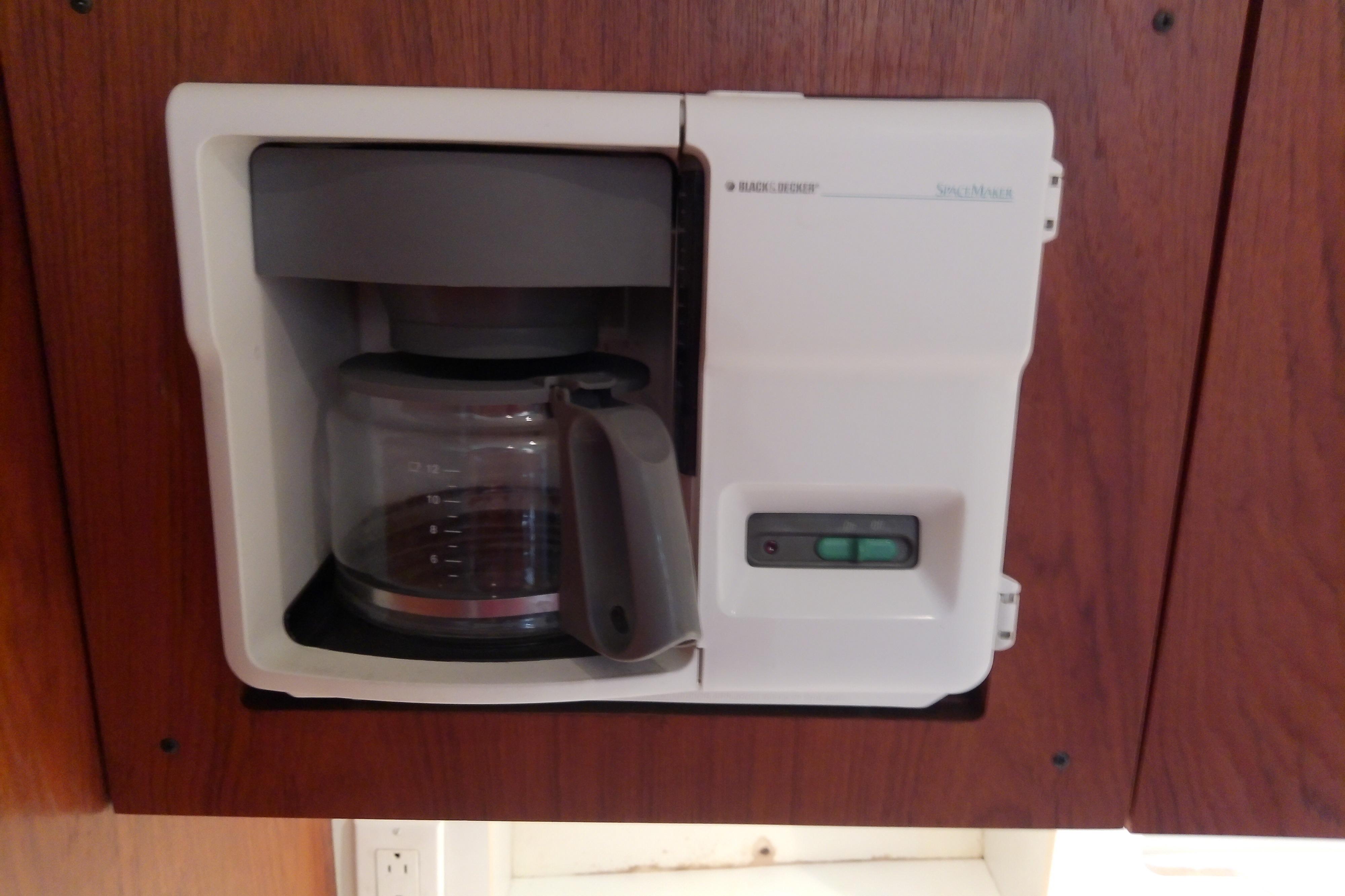 Built-in coffee maker on a 2000 Tiara Yachts 4100 Open, set in wooden cabinetry.