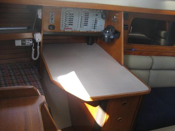 Interior of a 1984 C&C Landfall with navigation area and wooden furnishings.
