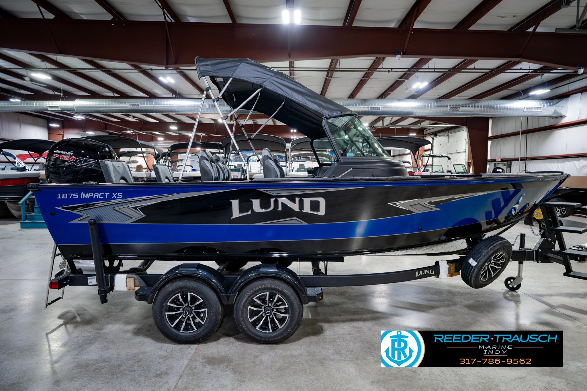2026 Lund 1875 Impact XS boat in showroom, featuring sleek design and modern features.