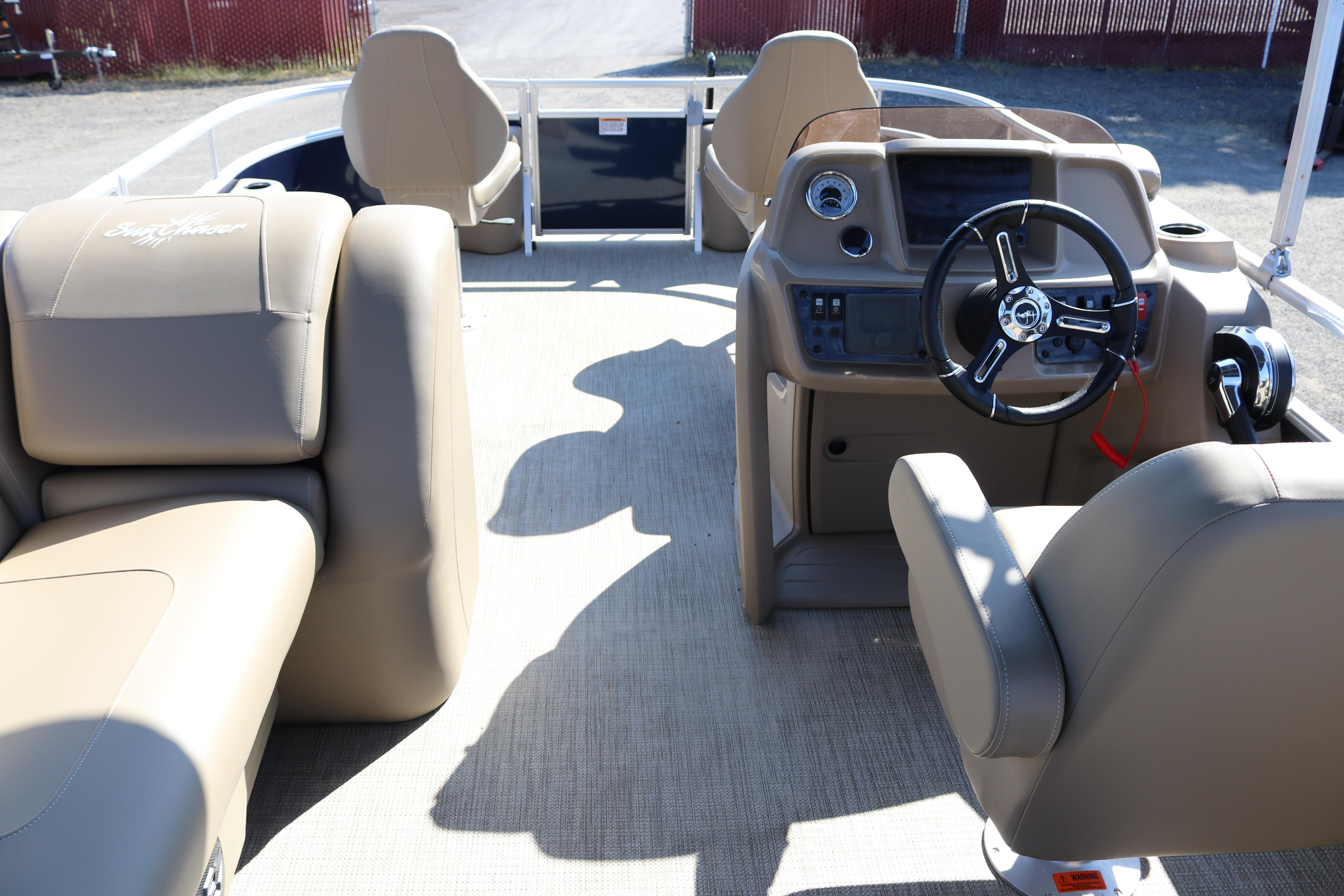 Interior of 2025 Sun Chaser Vista Fish 18 boat with beige seating and modern dashboard.
