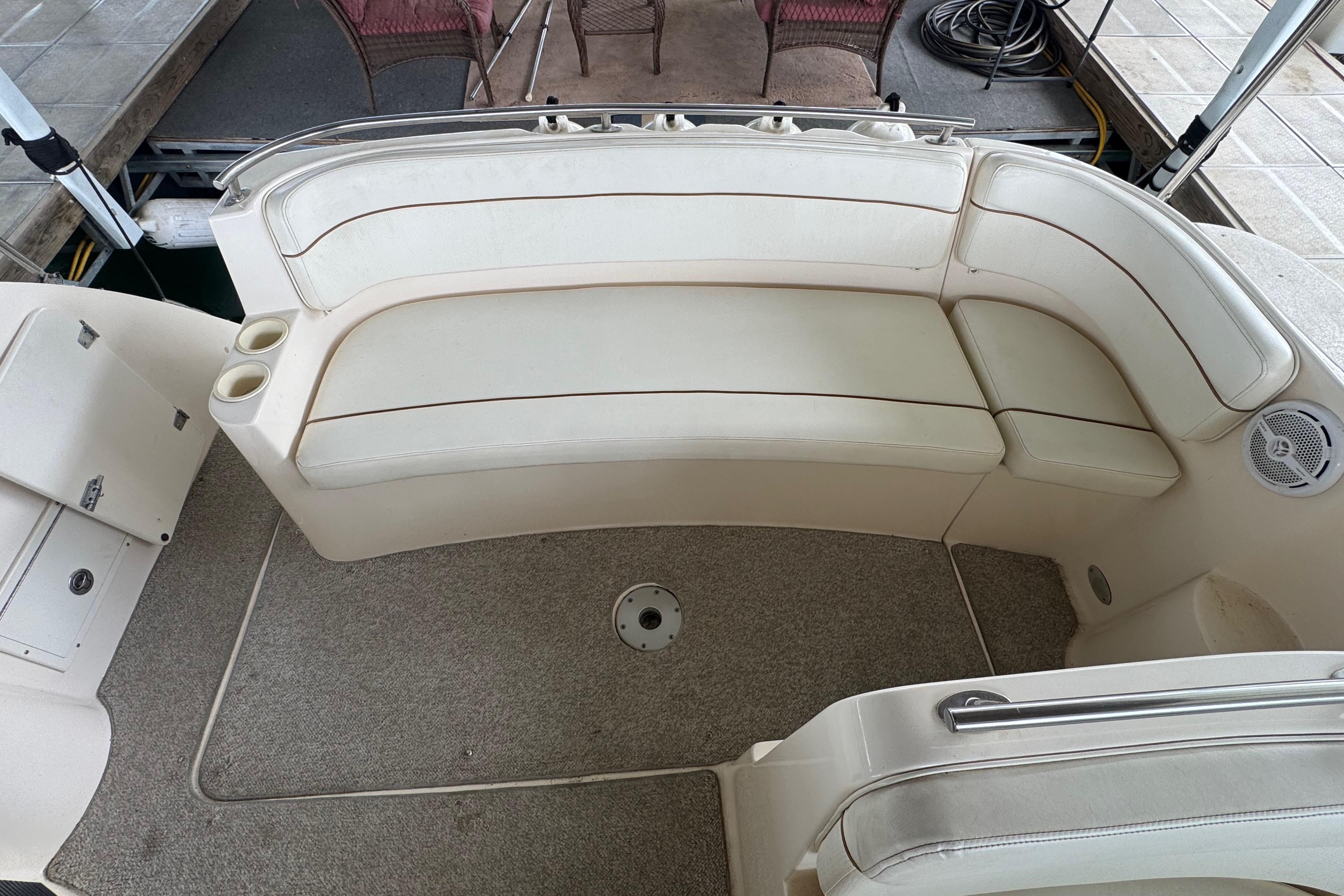 2004 Rinker Fiesta Vee 312 boat interior with beige seating and carpeted floor.