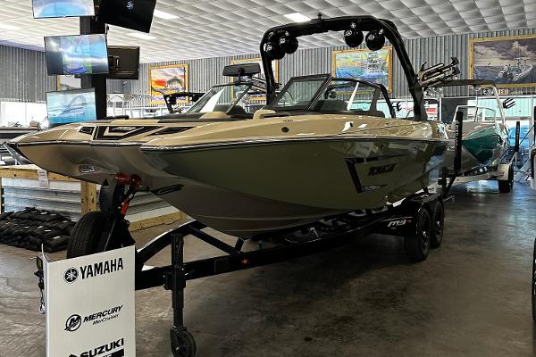2024 MB F22 Tomcat boat on display in showroom with Yamaha, Mercury, and Suzuki signage.