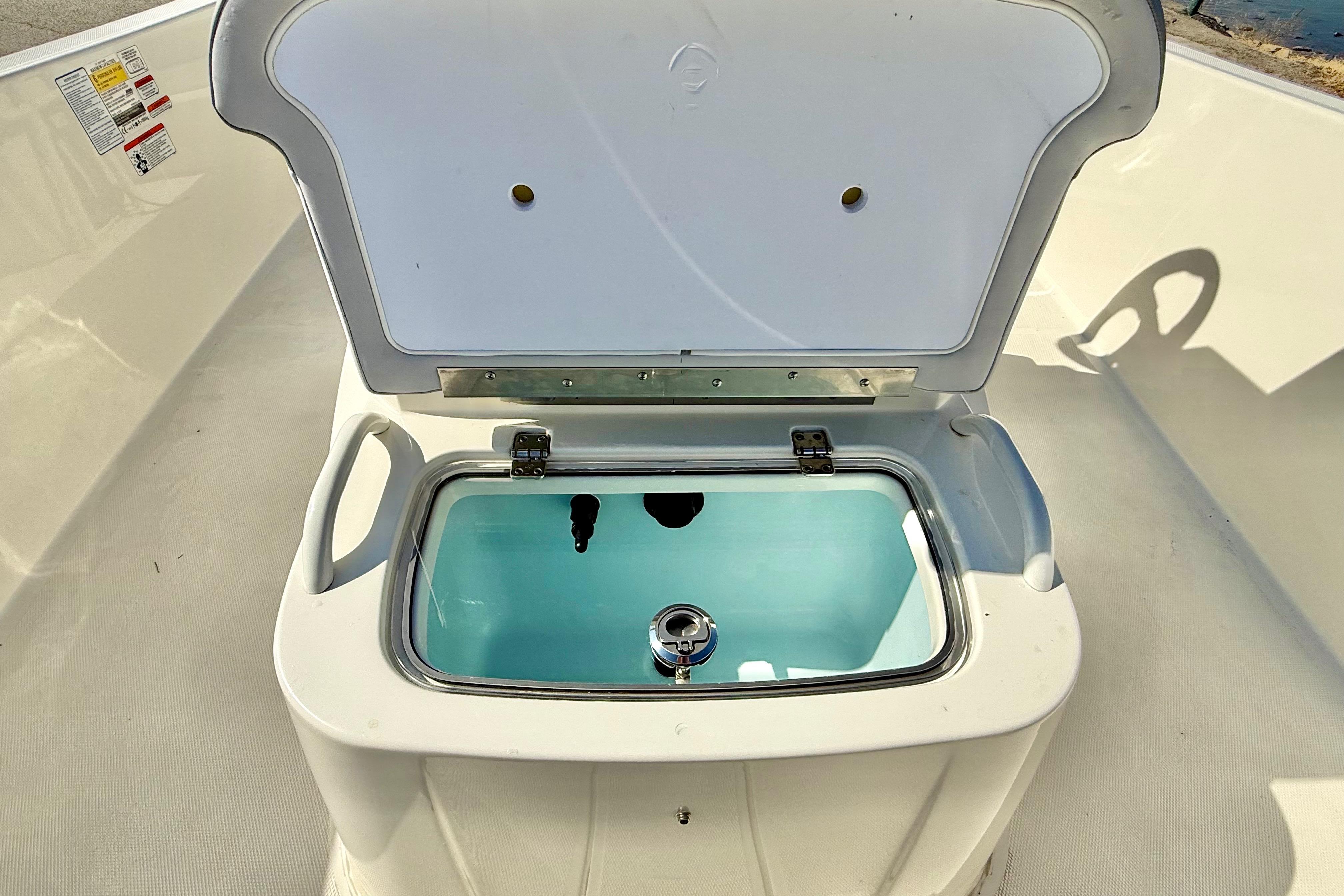 2024 Mako Pro Skiff 19 CC livewell with open lid, showcasing interior design.