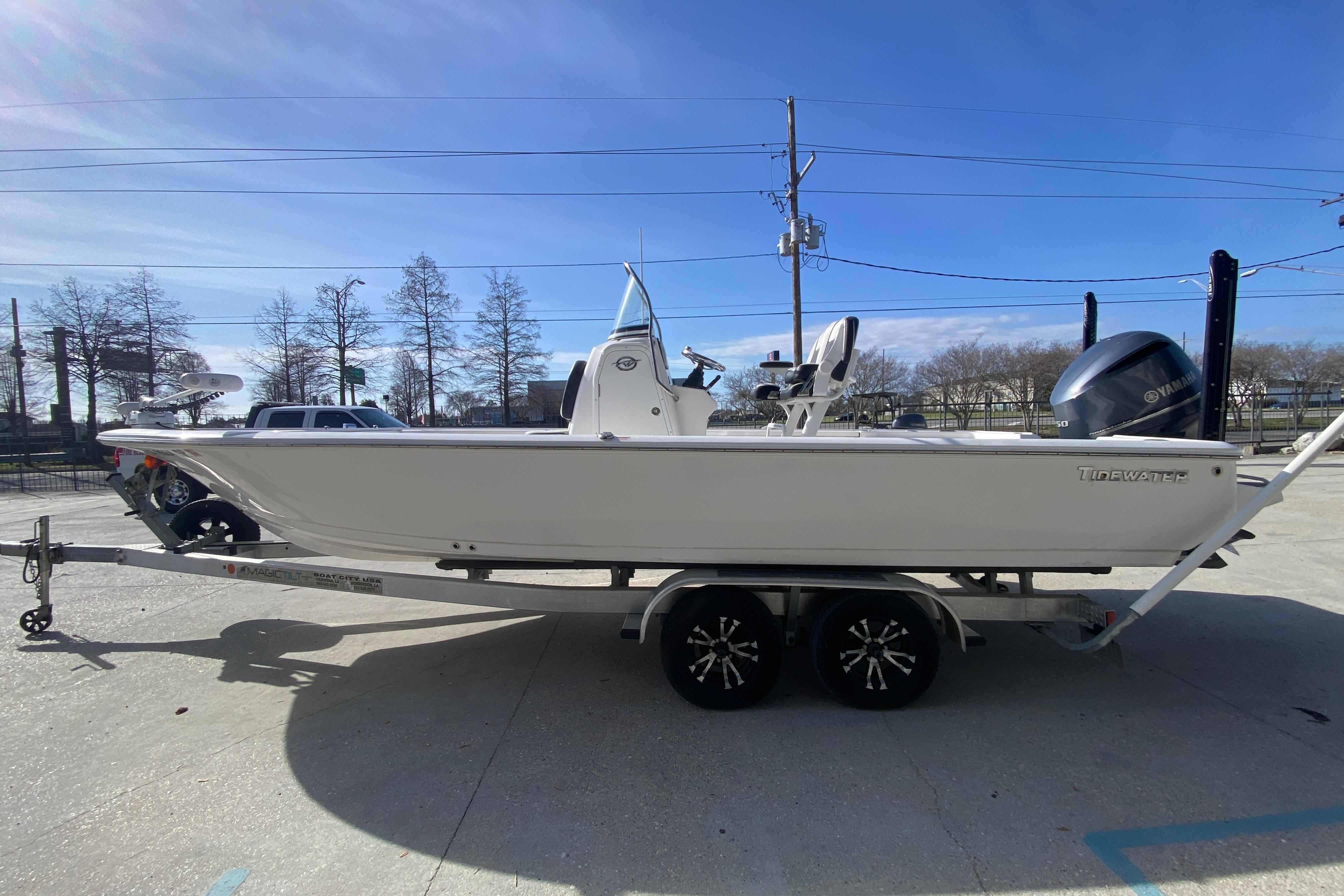 2023 Tidewater 2410 Bay Max boat on trailer, side view under clear blue sky.