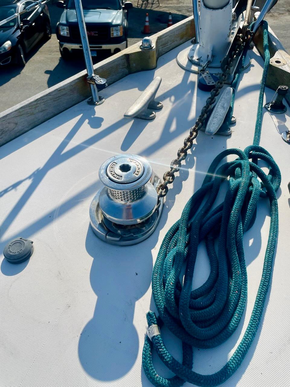 Deck of a 1981 Bristol 40 sailboat with winch, chain, and coiled rope.