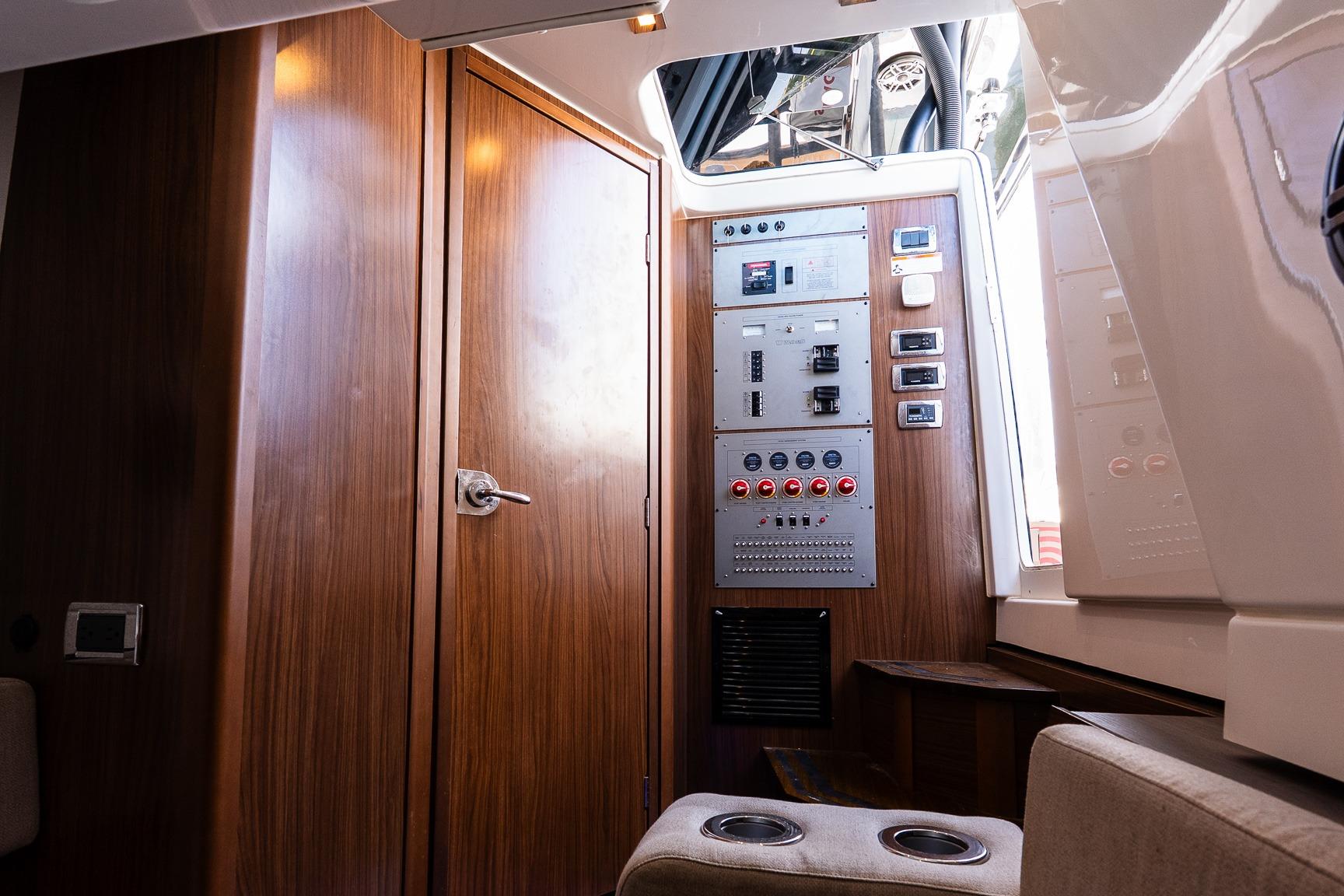 Interior of 2021 Wellcraft 402 Fisherman boat with control panel and wooden finish.