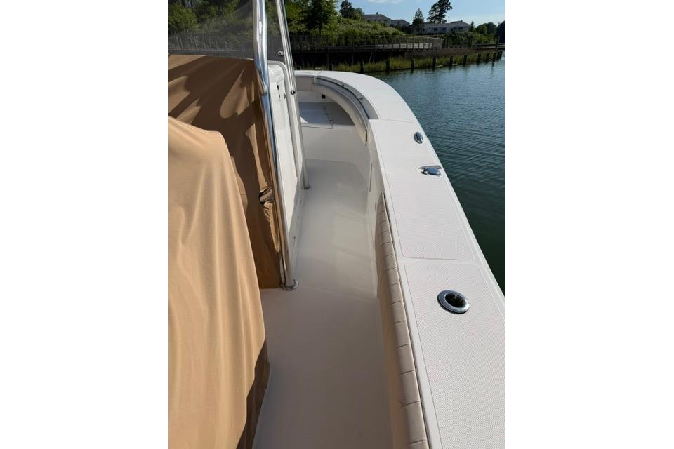2014 Southport 29 FE boat deck with beige cover, docked by calm water.