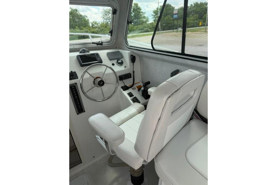 Interior of a 2016 Parker 2520 Sport Cabin boat with steering wheel and controls.