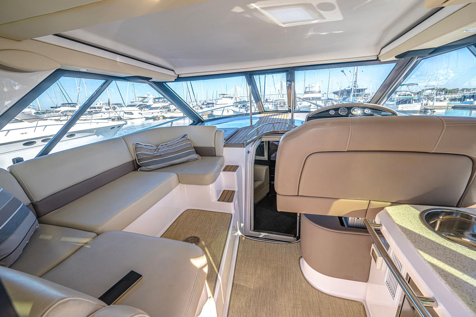 Luxurious interior of 2016 Regal 46 Sport Coupe yacht with marina view.