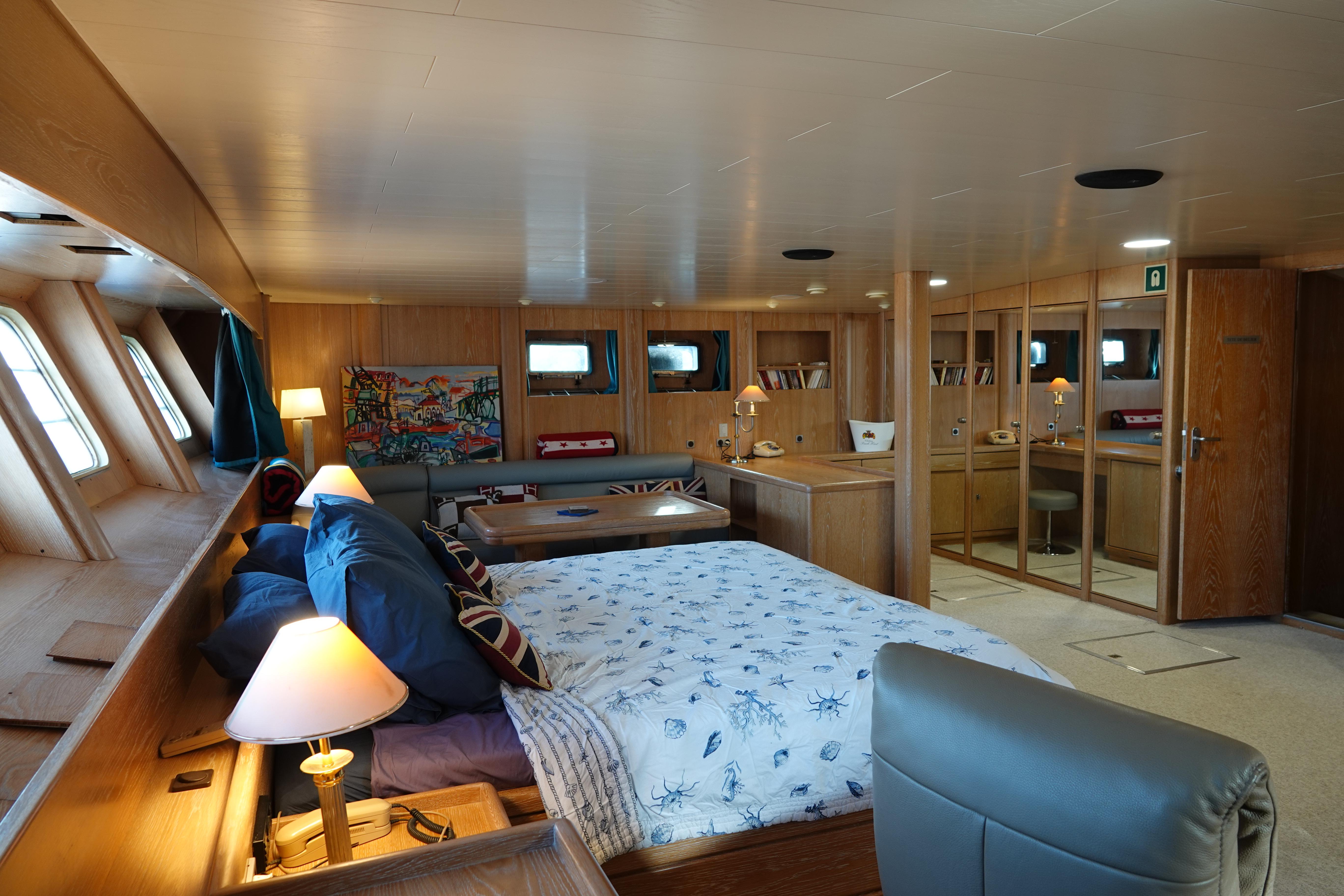 Luxurious interior of 1990 One Design Deck House Cutter Rigged Sloop with cozy bedroom and seating area.