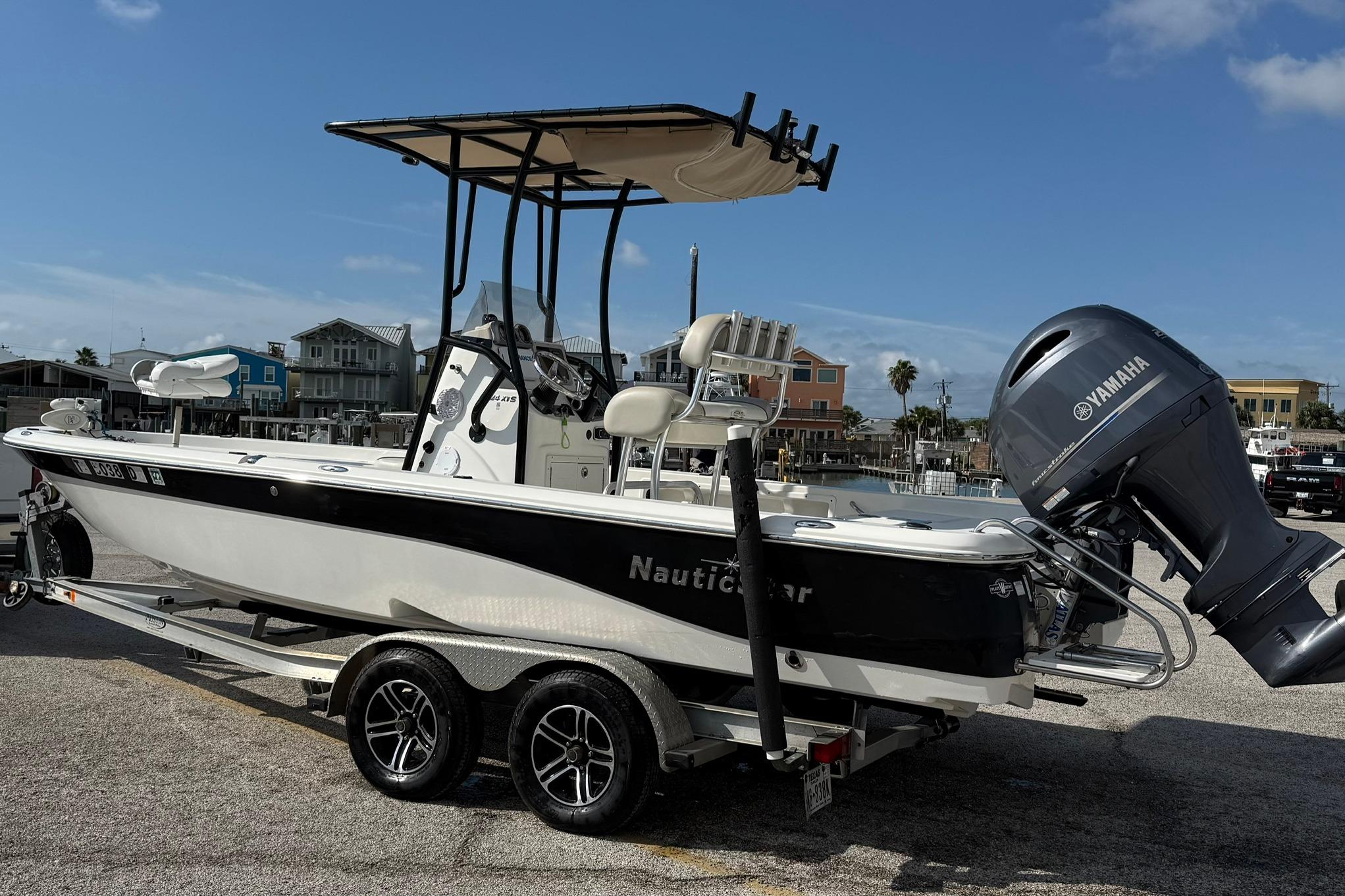 2015 NauticStar 224 XTS boat with Yamaha engine on trailer, dockside view.