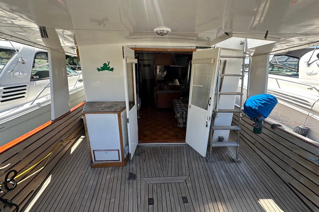1983 Kadey-Krogen Krogen 42 Trawler deck with wooden flooring and open cabin doors.