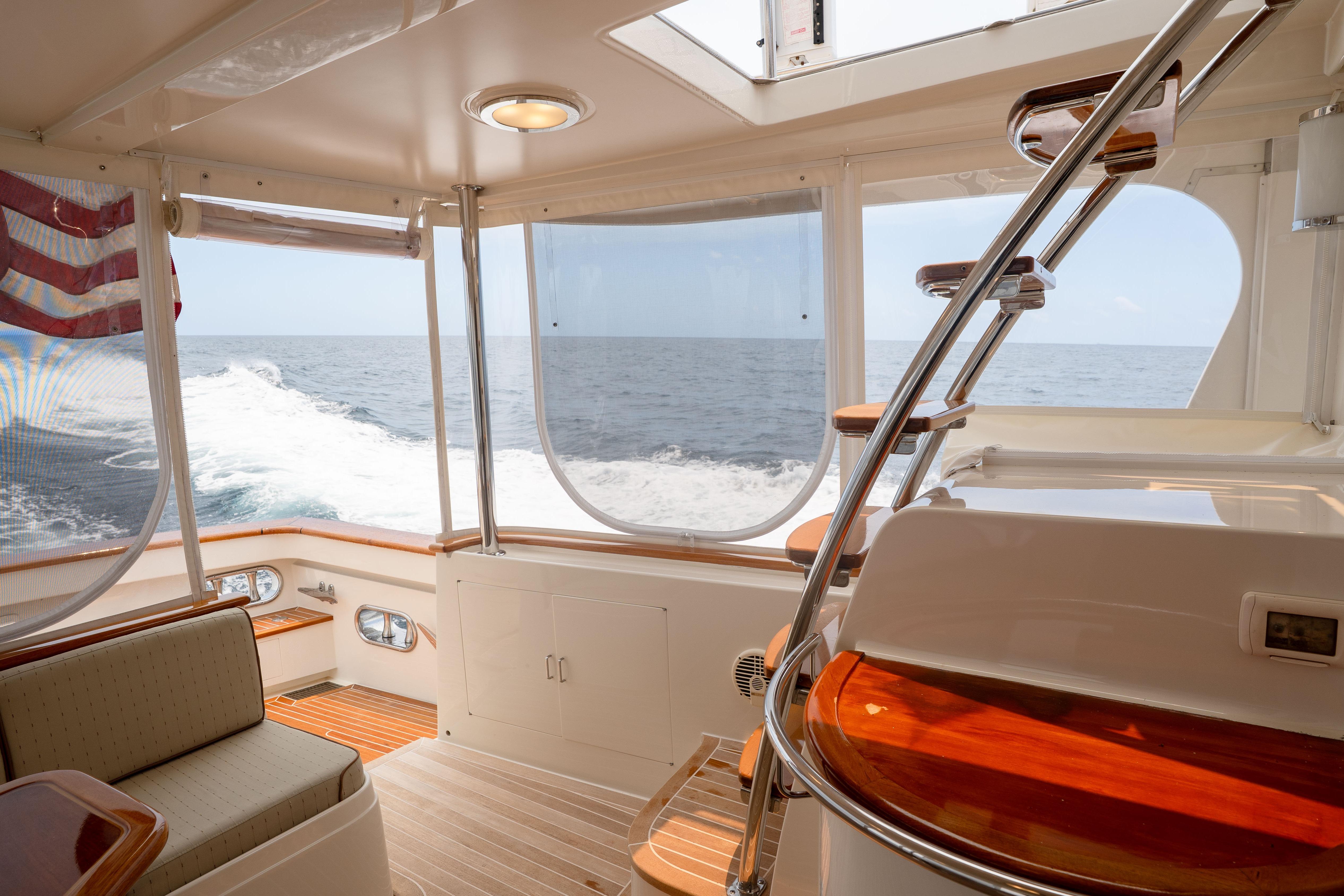 Luxurious 2006 Fleming 75 yacht interior with ocean view and elegant wooden finishes.
