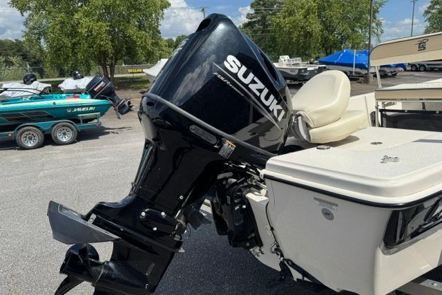 2023 Carolina Skiff 192 JLS with Suzuki outboard motor in a boatyard setting.