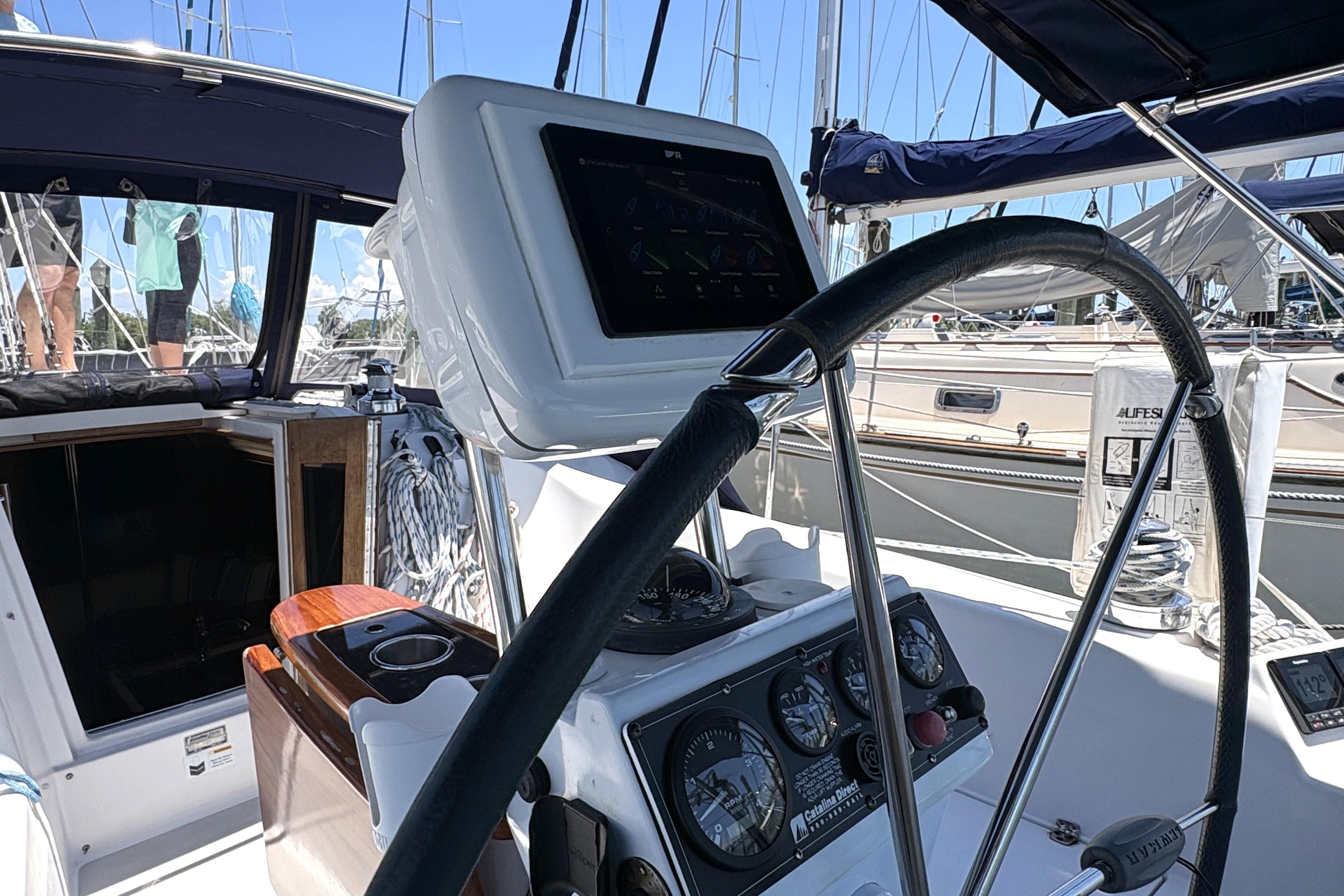 Cockpit of a 2011 Catalina 355 sailboat with steering wheel and navigation instruments.