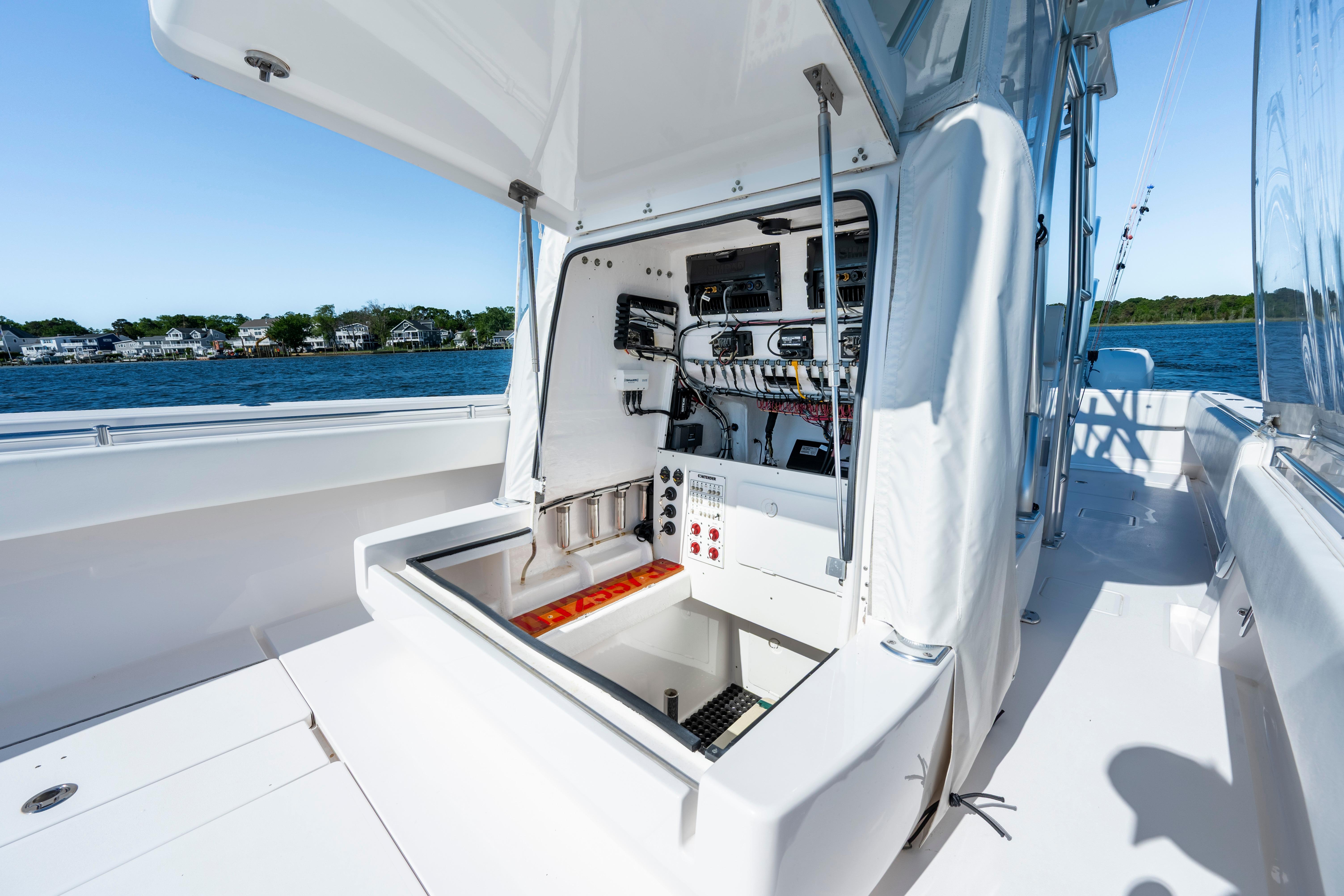 2015 Contender 39 ST boat with open console, showcasing interior electronics and wiring by the water.
