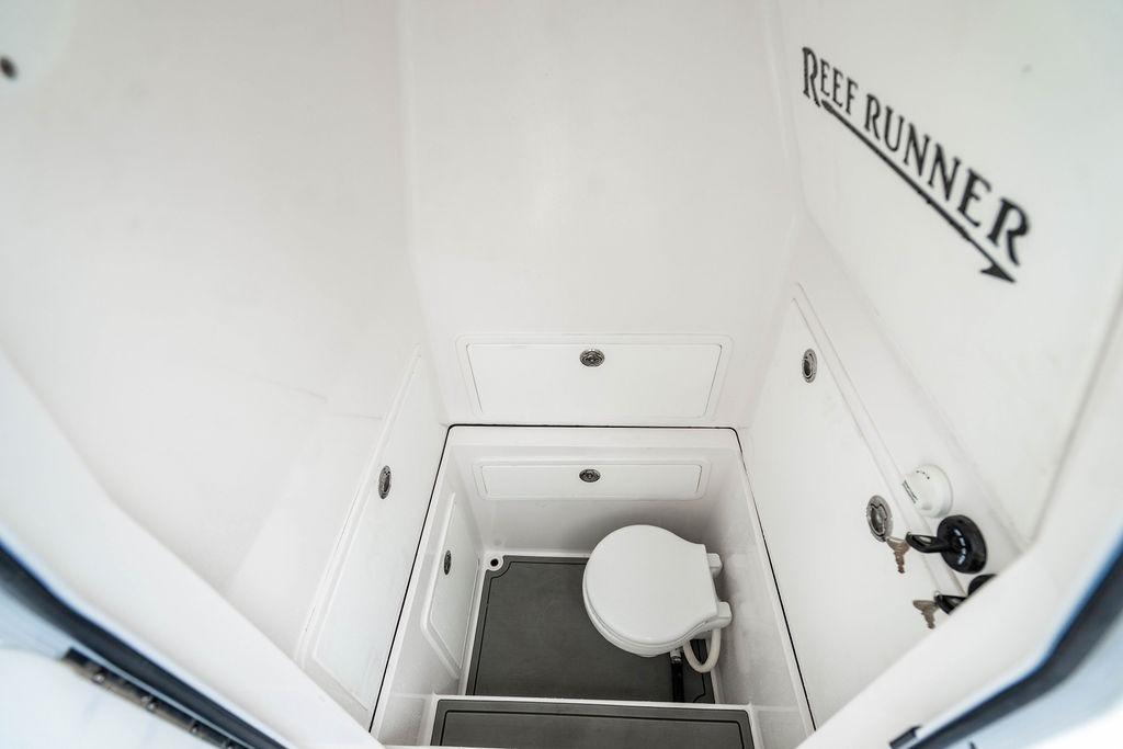 2027 Reef Runner 280 boat interior with compact marine toilet.