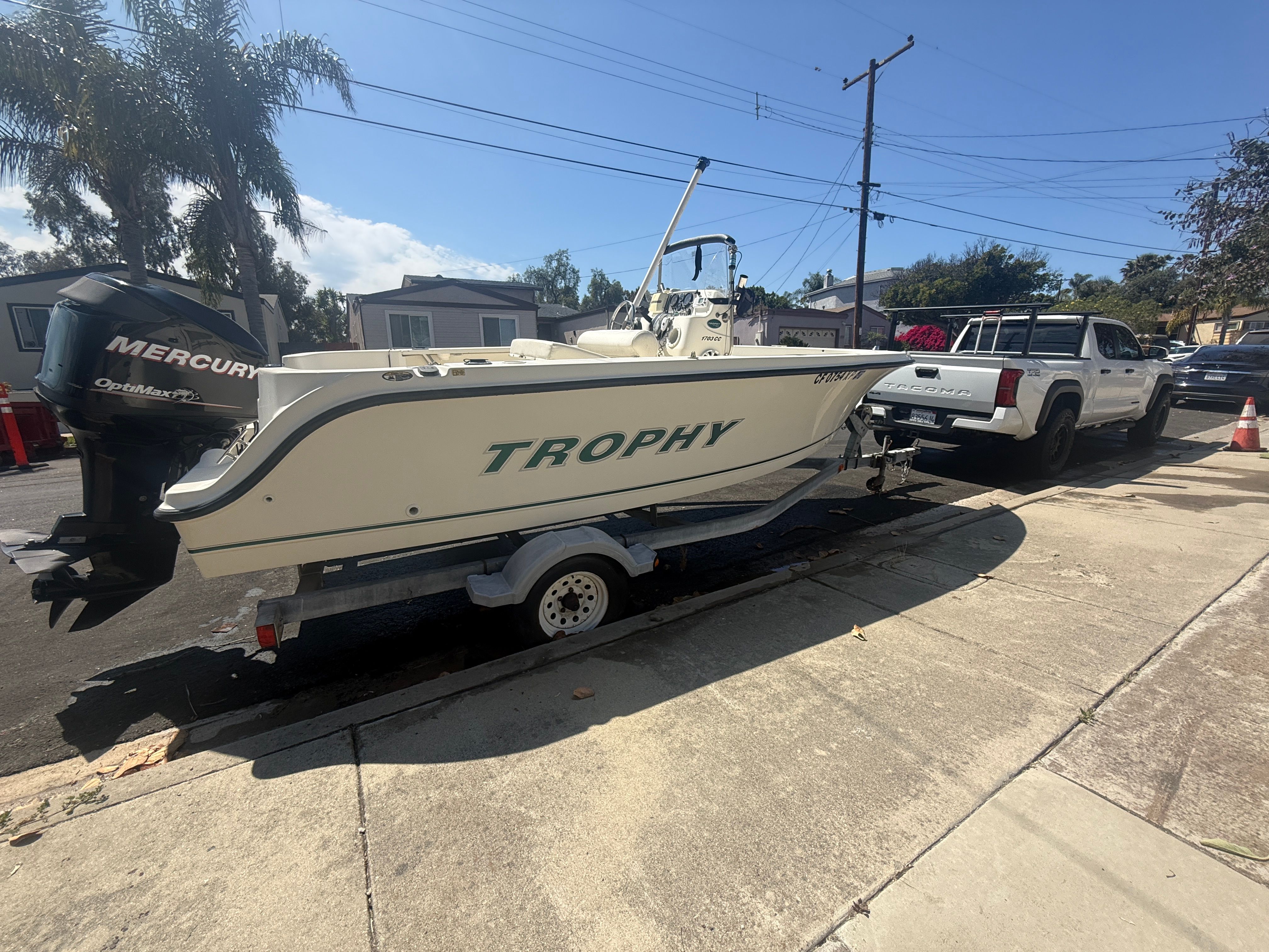 2008 Trophy 1703 Center Console boat on trailer, parked beside a pickup truck.