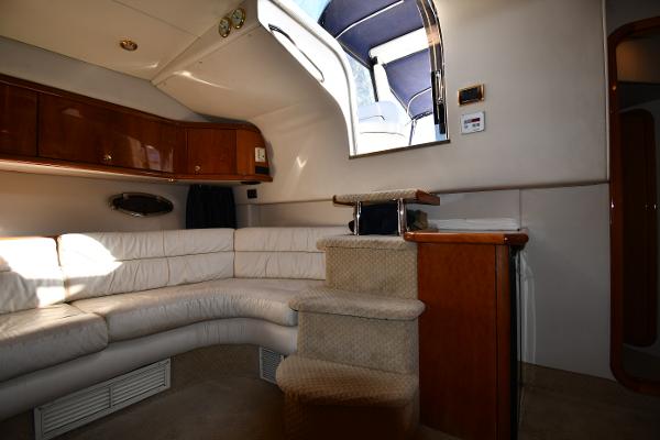 Interior of 1997 Sunseeker Camargue 47 yacht with white leather seating and wooden cabinetry.