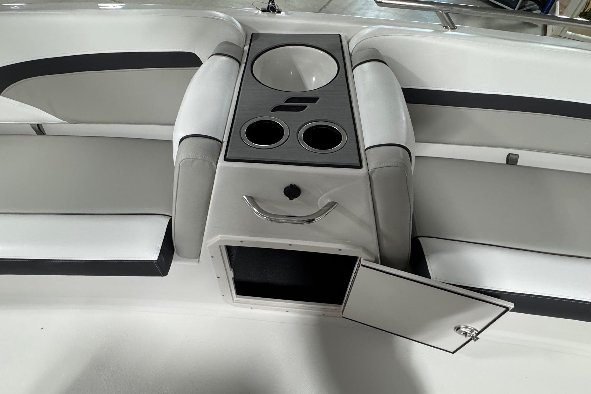 2026 Starcraft SVX 191 OB boat interior with seating, cup holders, and storage compartment.