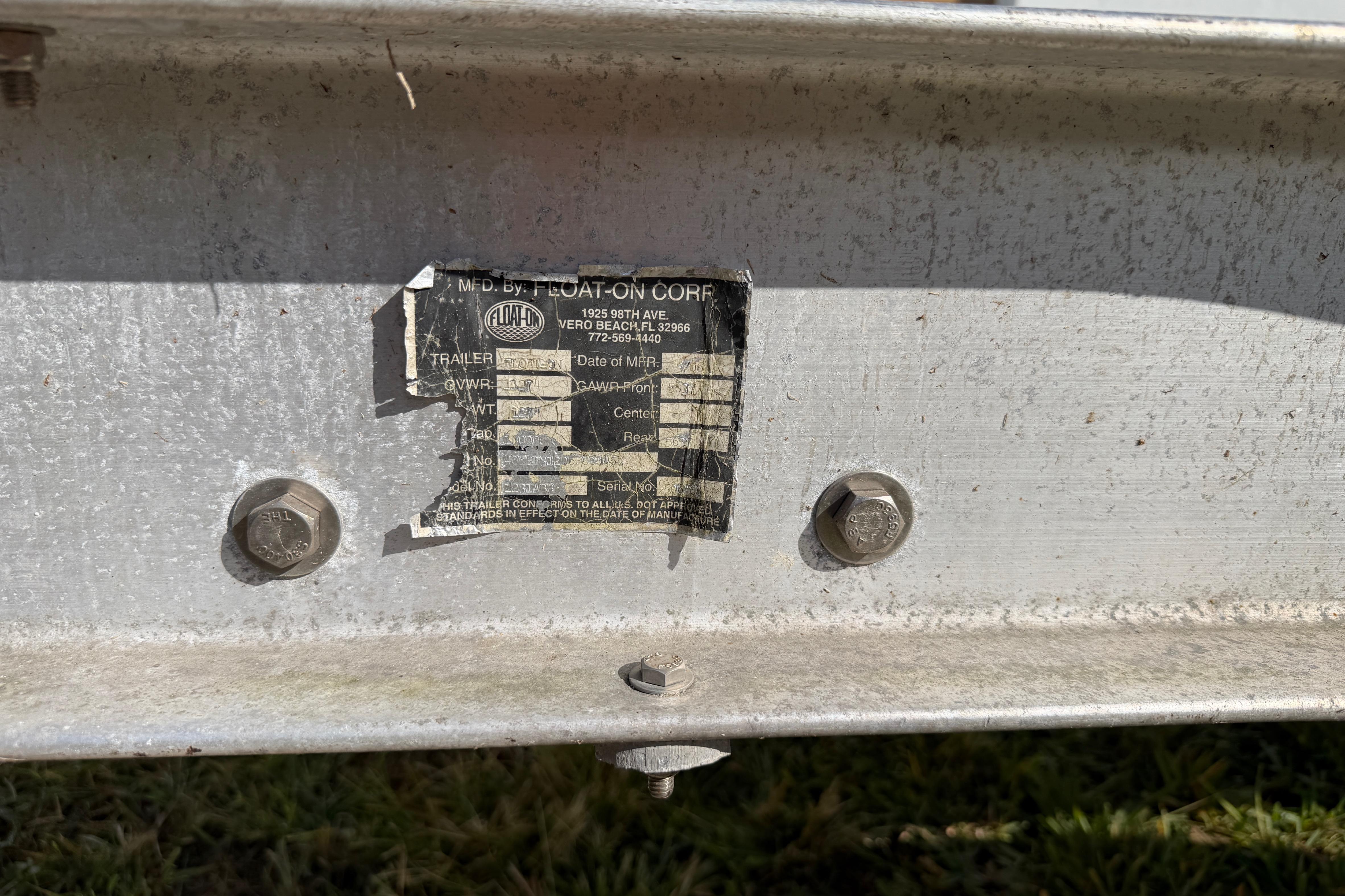 2006 Grady-White Sailfish 282 trailer label with bolts, showing wear and details.
