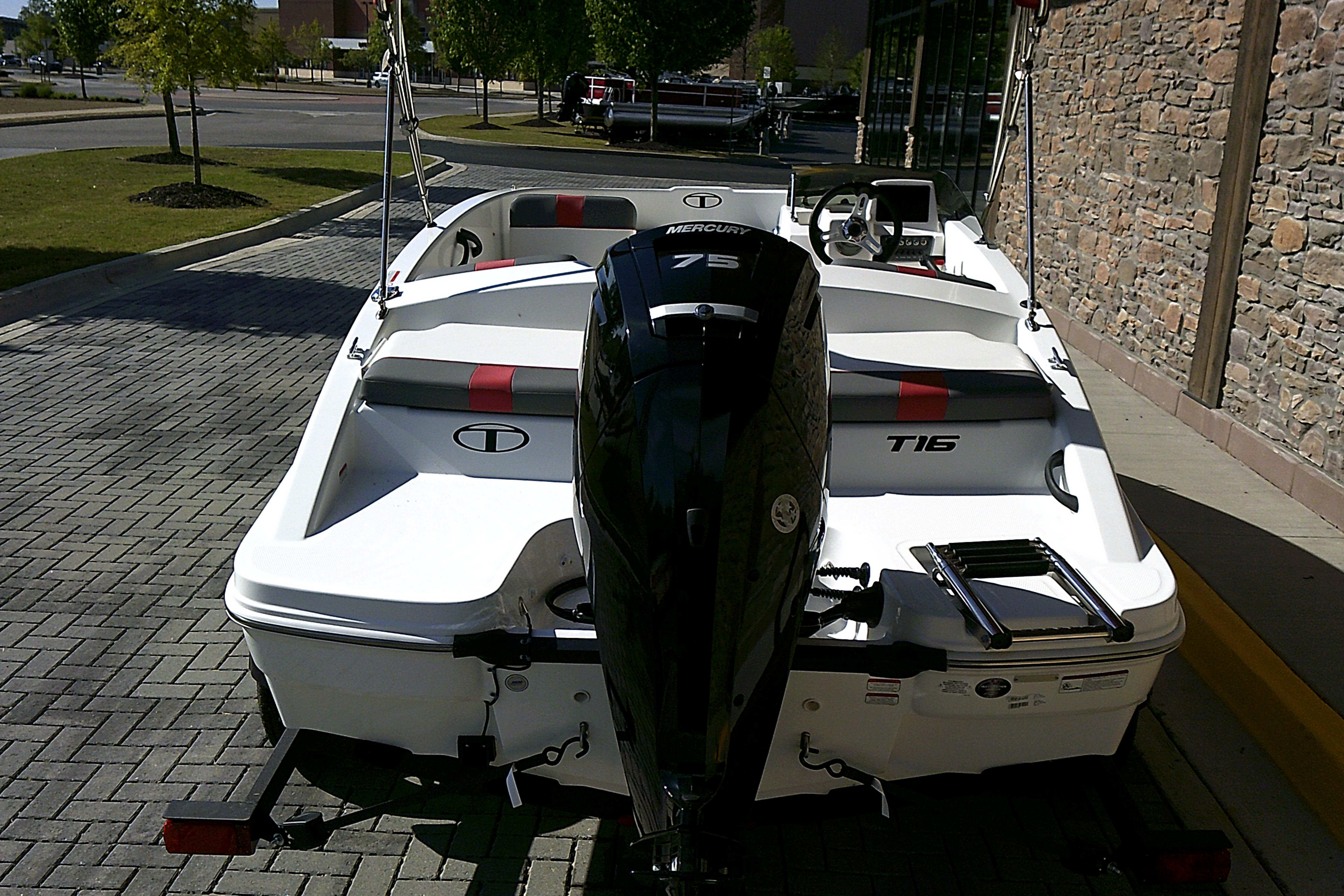 2025 Tahoe T16 boat with Mercury 75 engine, parked on a paved area.