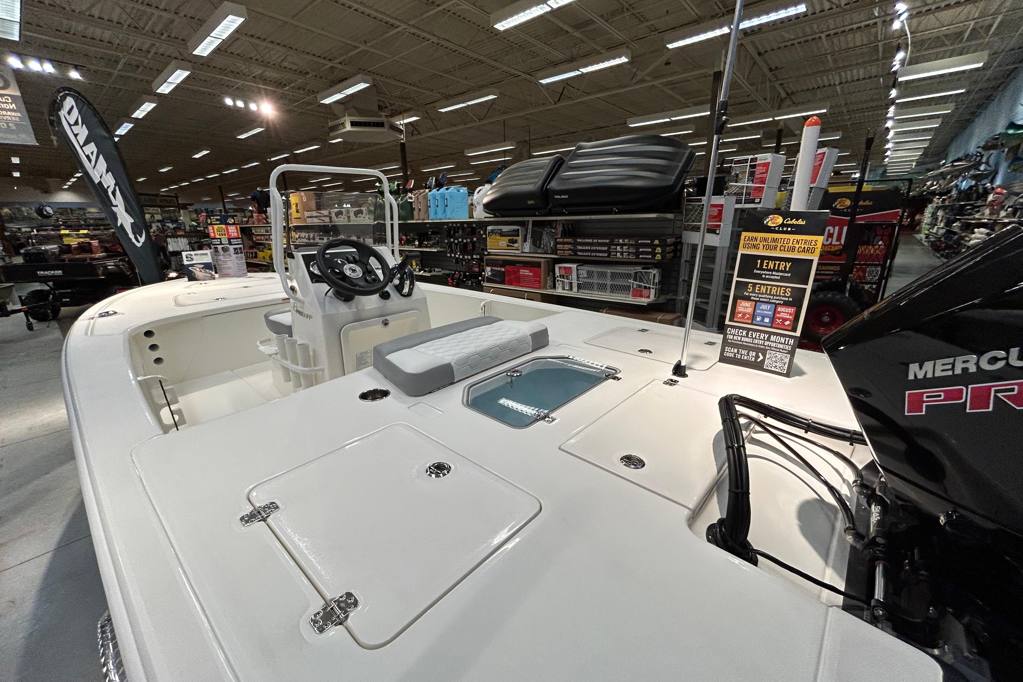2026 Mako 18 Pro Skiff boat displayed indoors with Mercury engine.