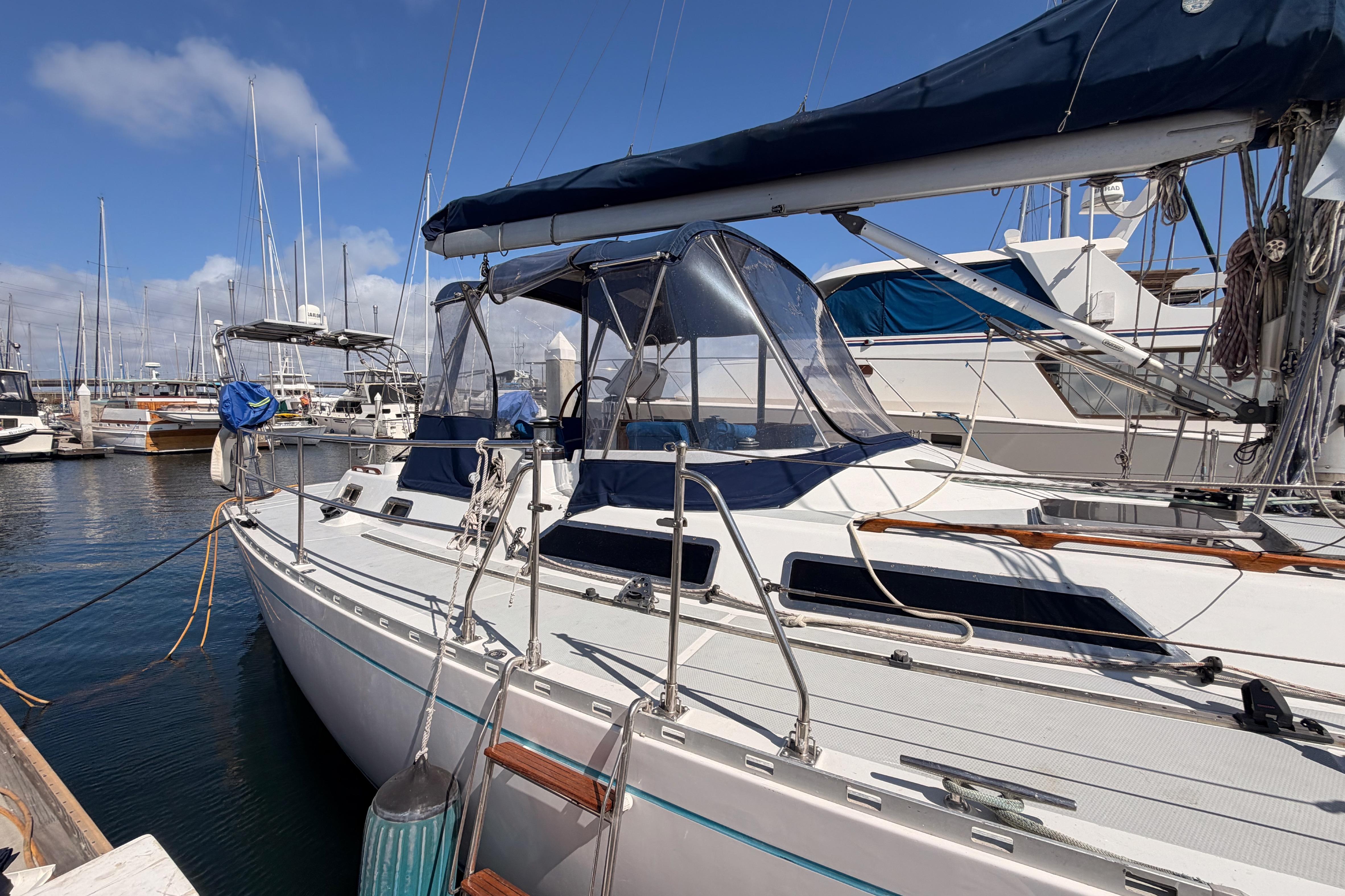 Sailboat docked at marina, Hylas 51 model, 1991, with blue canvas covers.