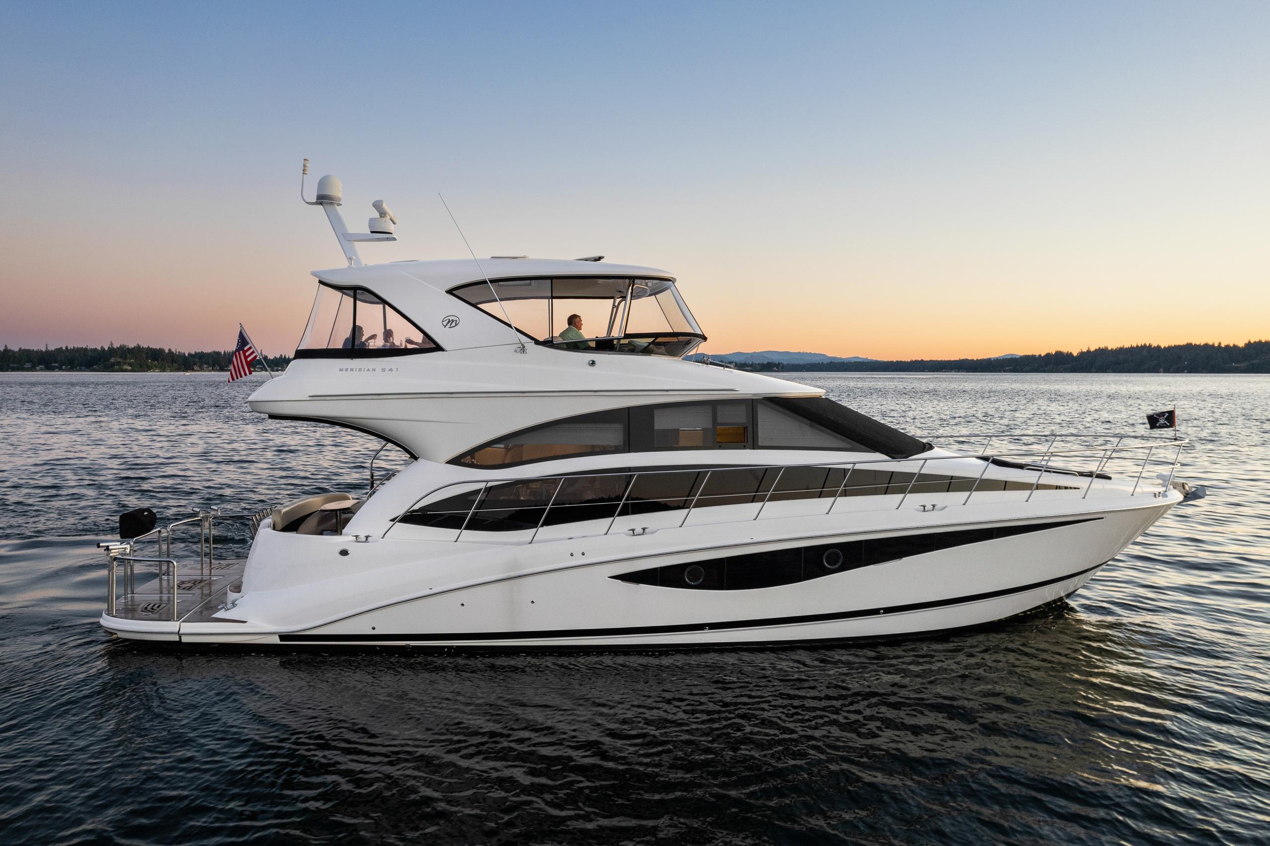 2012 Meridian 541 Sedan yacht cruising at sunset on calm waters.