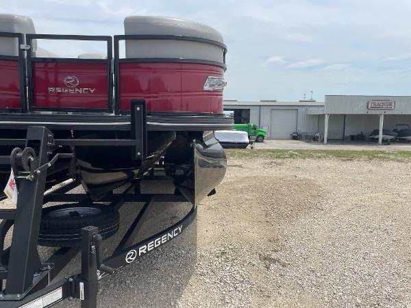 2023 Regency 250DL3 pontoon boat on trailer, parked outdoors near a building.