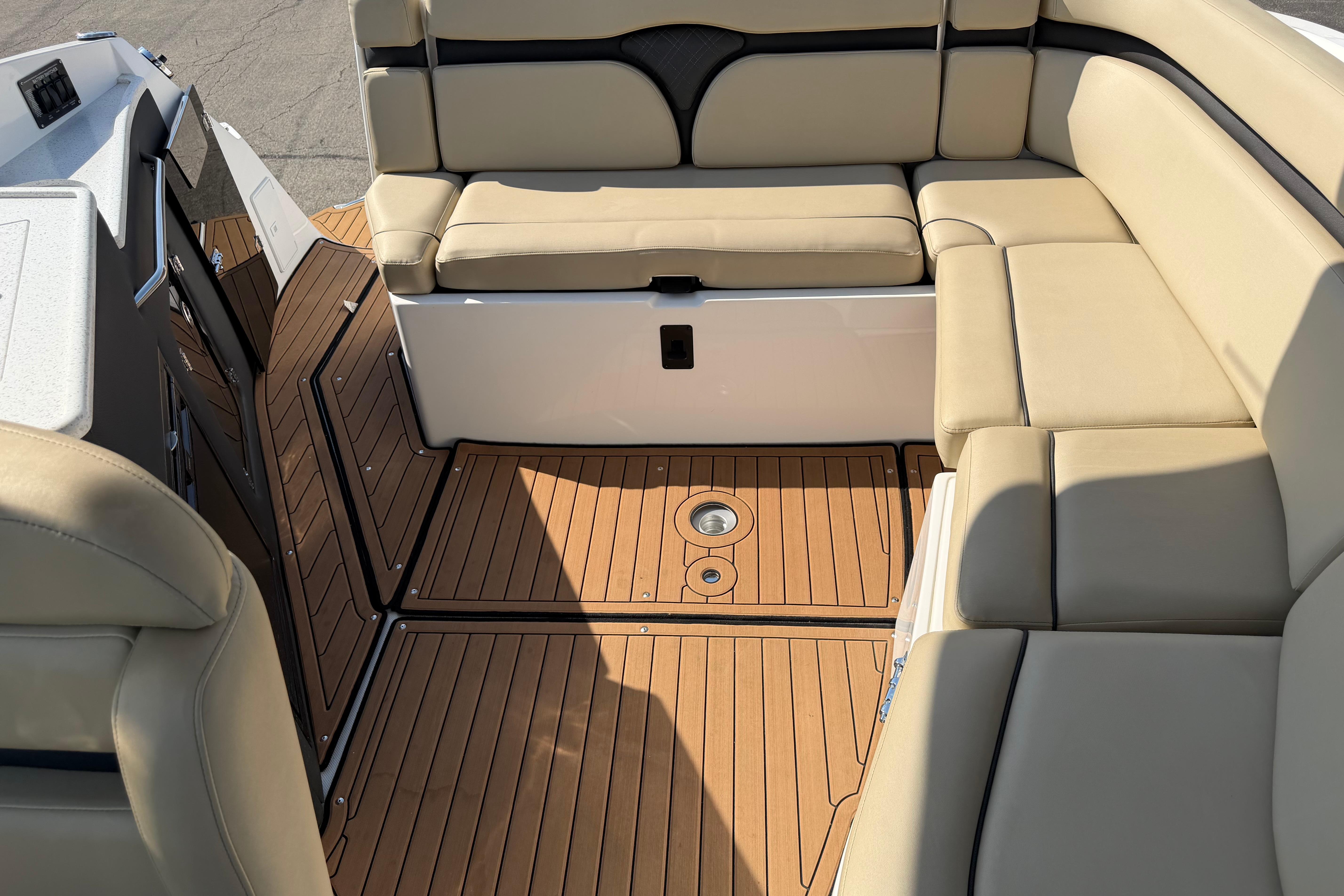 2019 Rinker EX 320 boat interior with beige seating and wooden flooring.