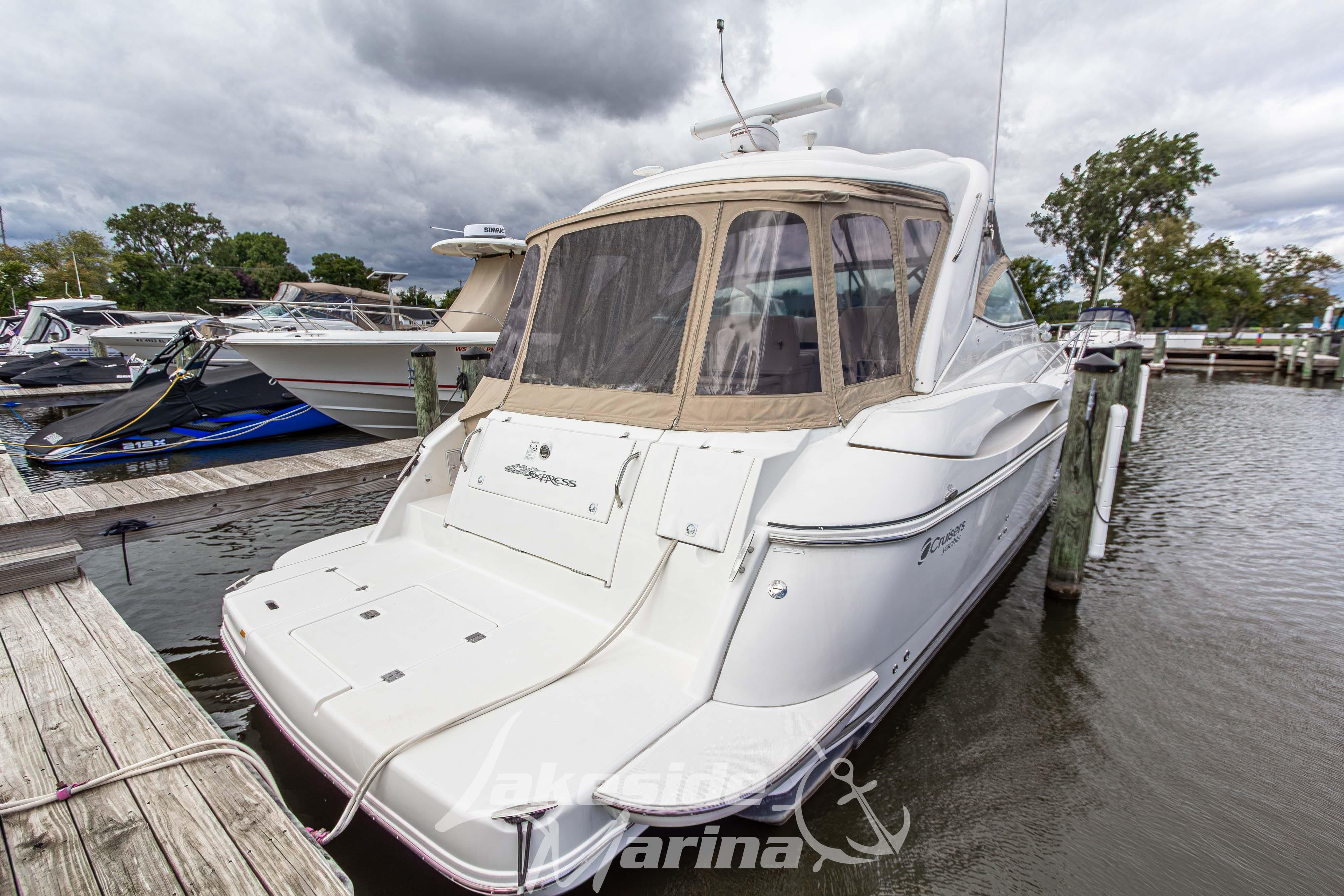 2006 Cruisers Yachts 420 Express docked at marina under cloudy skies.