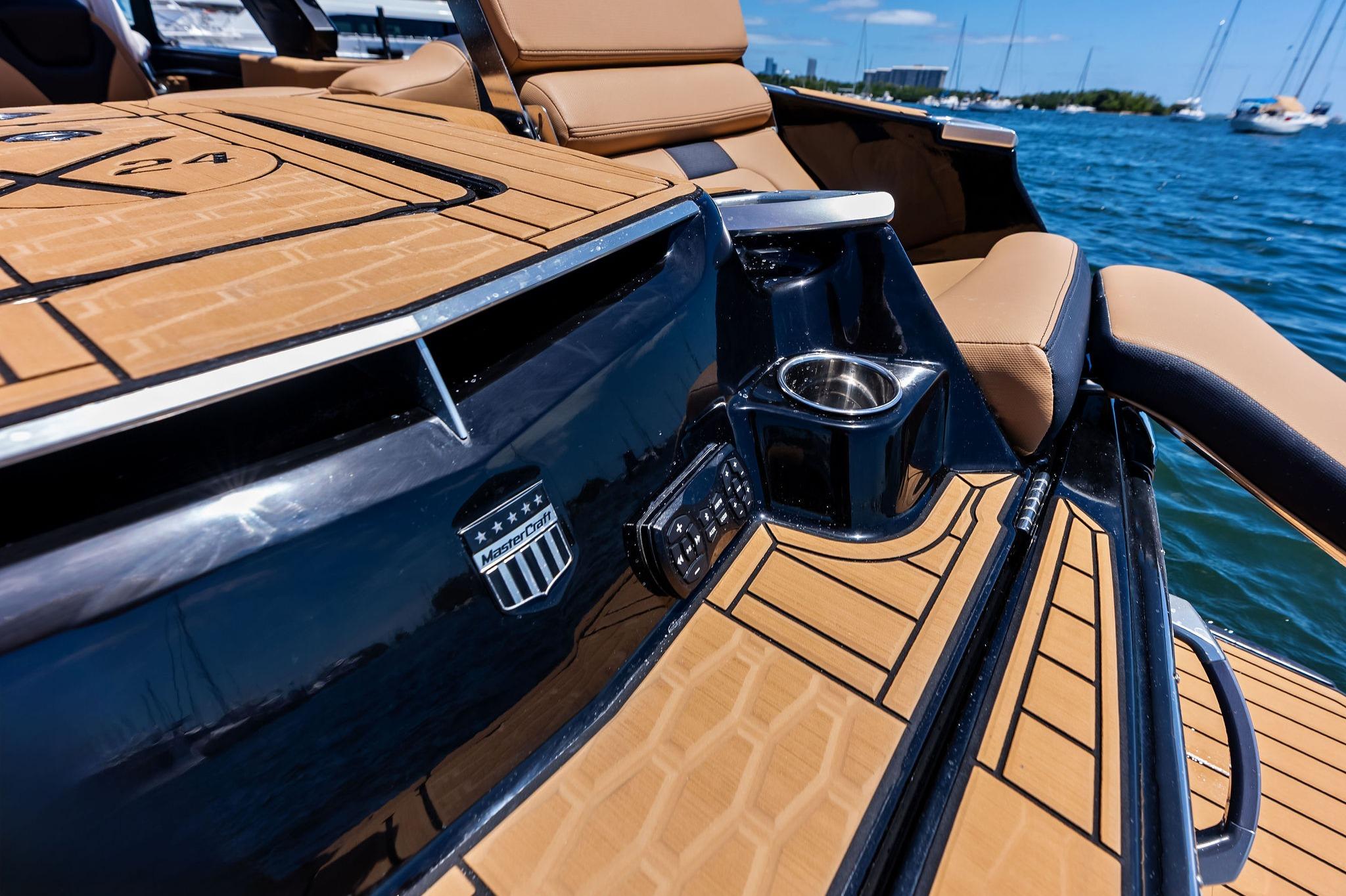 2024 MasterCraft X24 boat interior with tan seating, cup holder, and sleek design on the water.