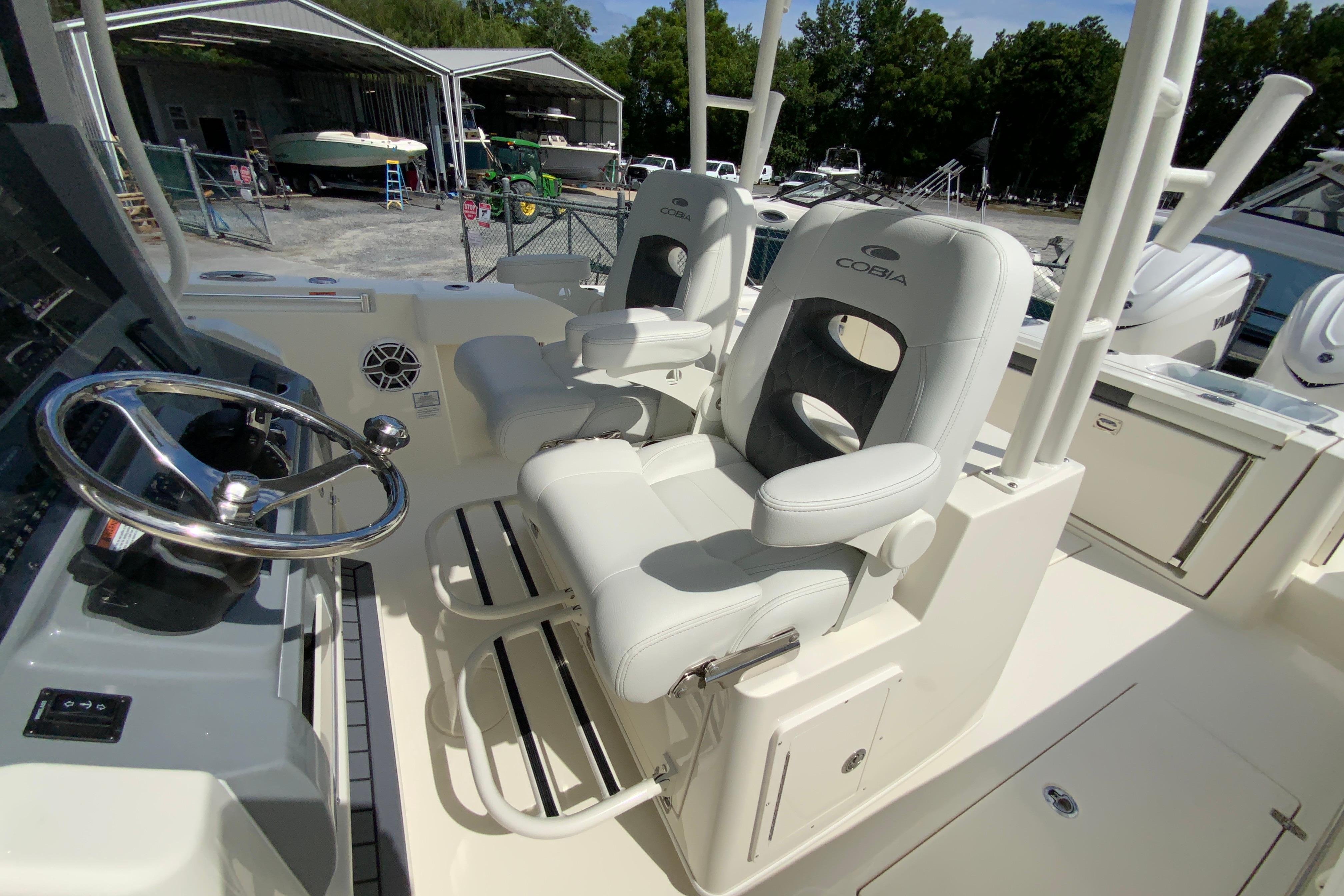 2027 Cobia 320 Center Console boat interior with dual captain's chairs and steering wheel.